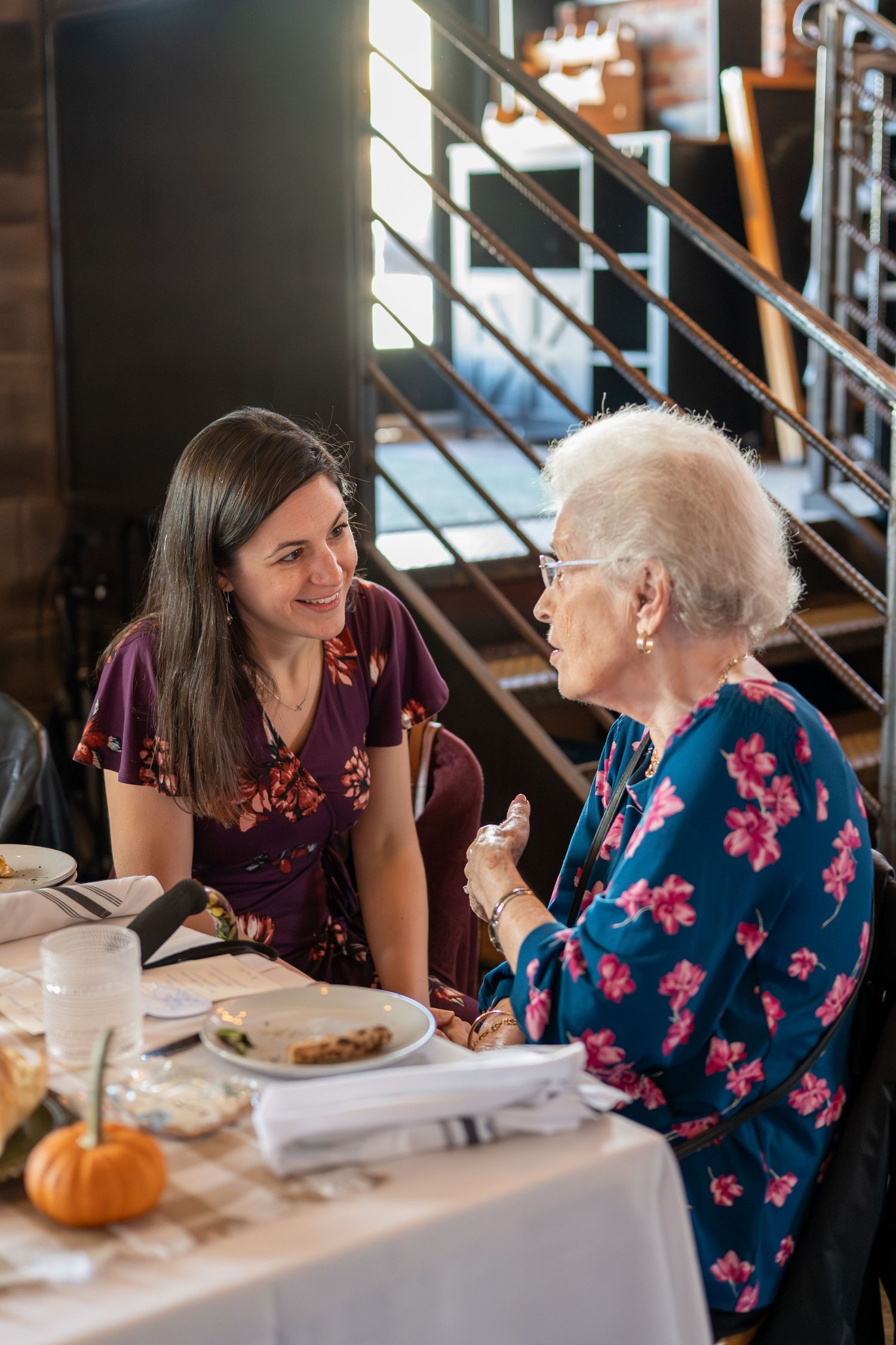 Two people having an animated conversation while dining at a restaurant with modern decor.