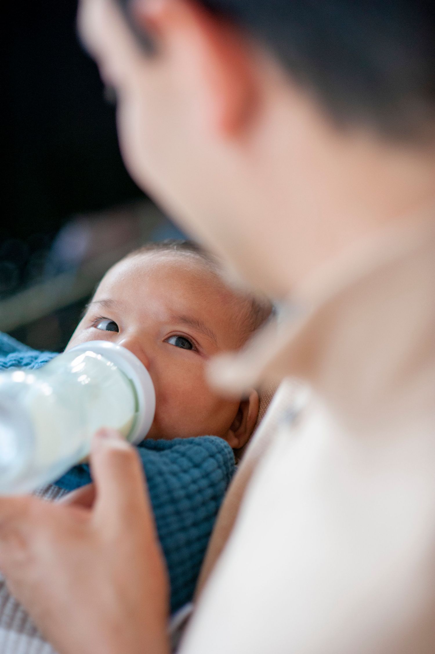 A baby being bottle fed in a close-up shot.