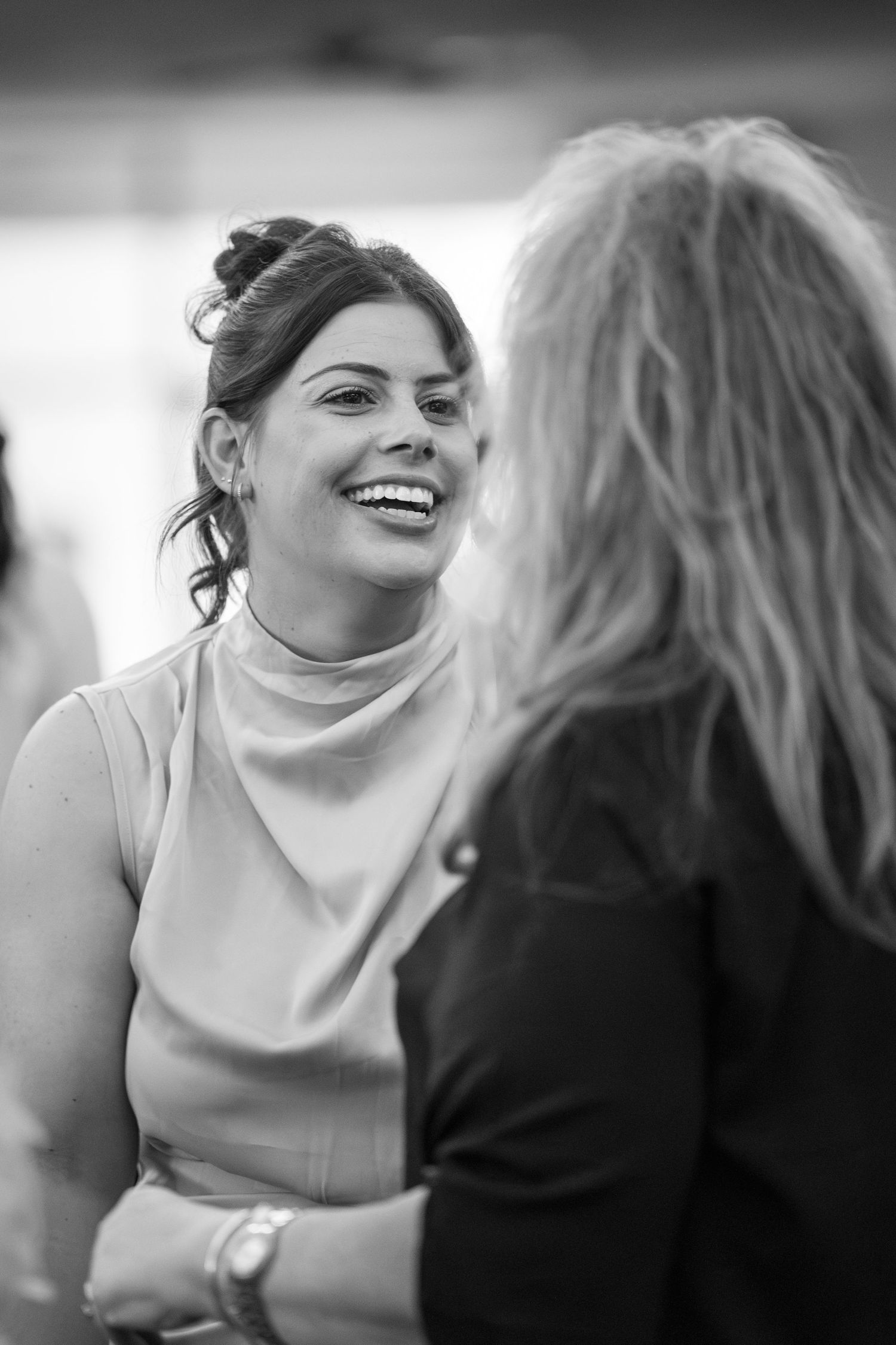 Two people engaged in joyful conversation in black and white photography.