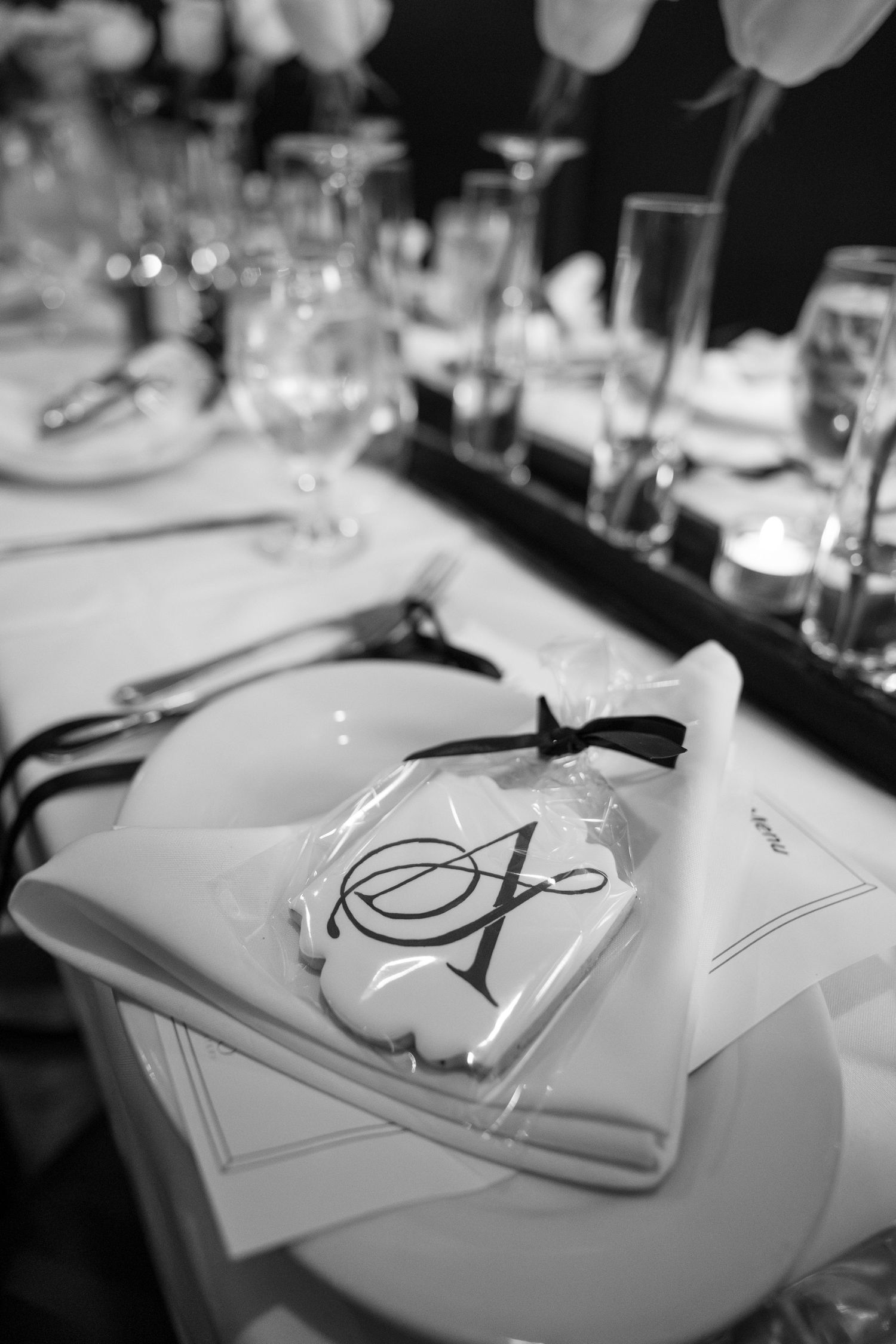 Elegant black and white table setting with calligraphy place cards at a formal dinner event.