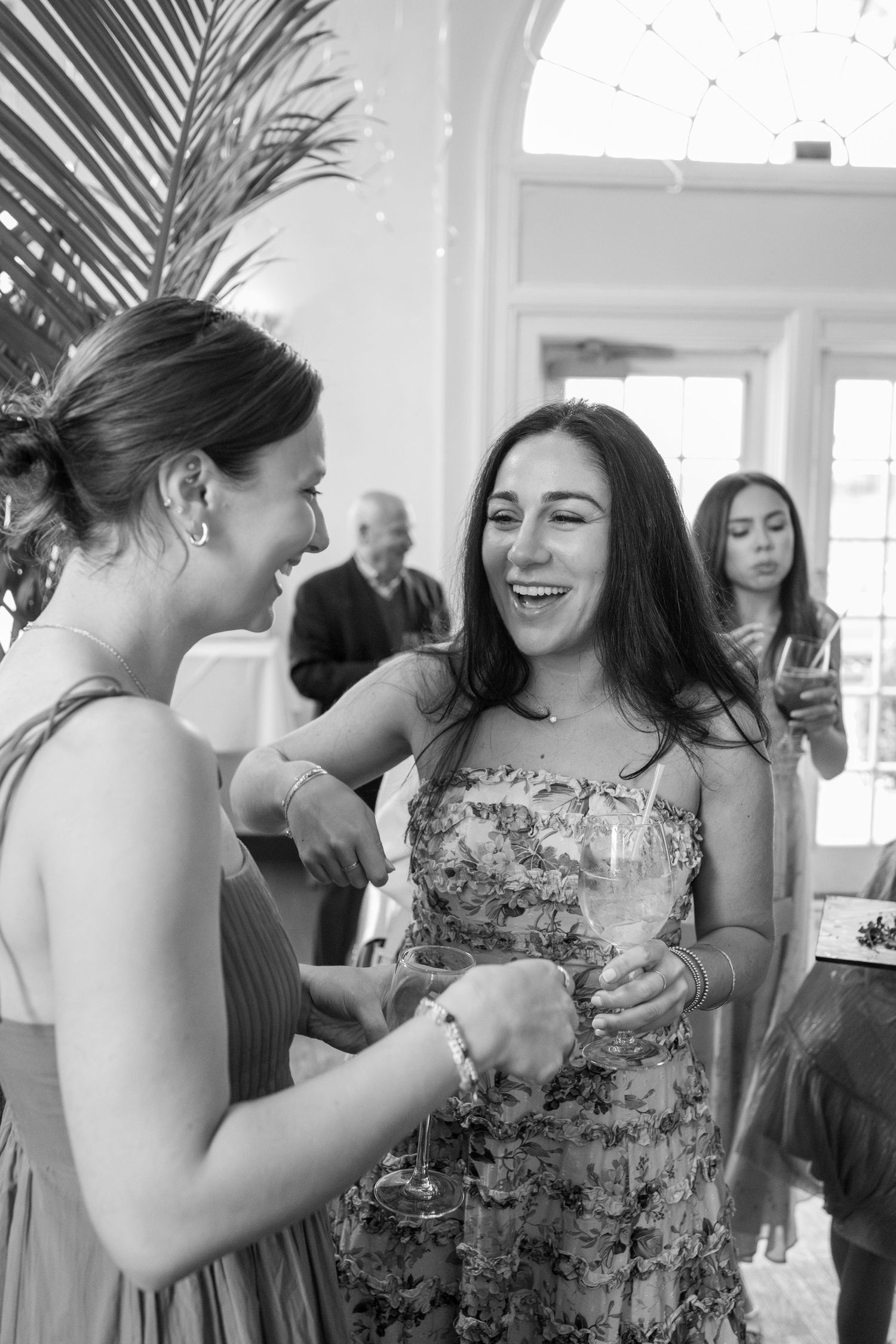 Two women laughing and celebrating together at a christening reception party.