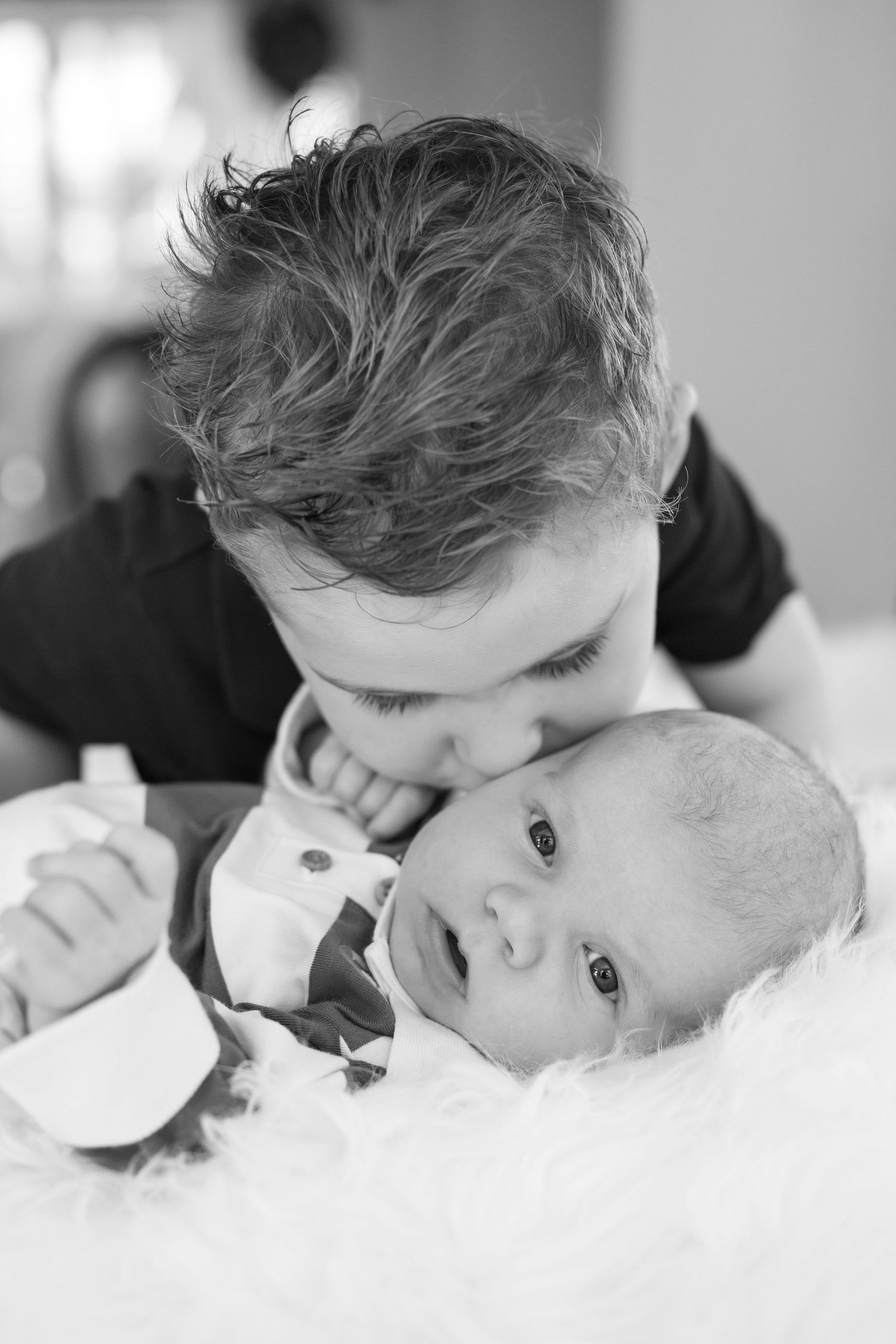 Black and white series showing playful close-up moments between parent and baby.