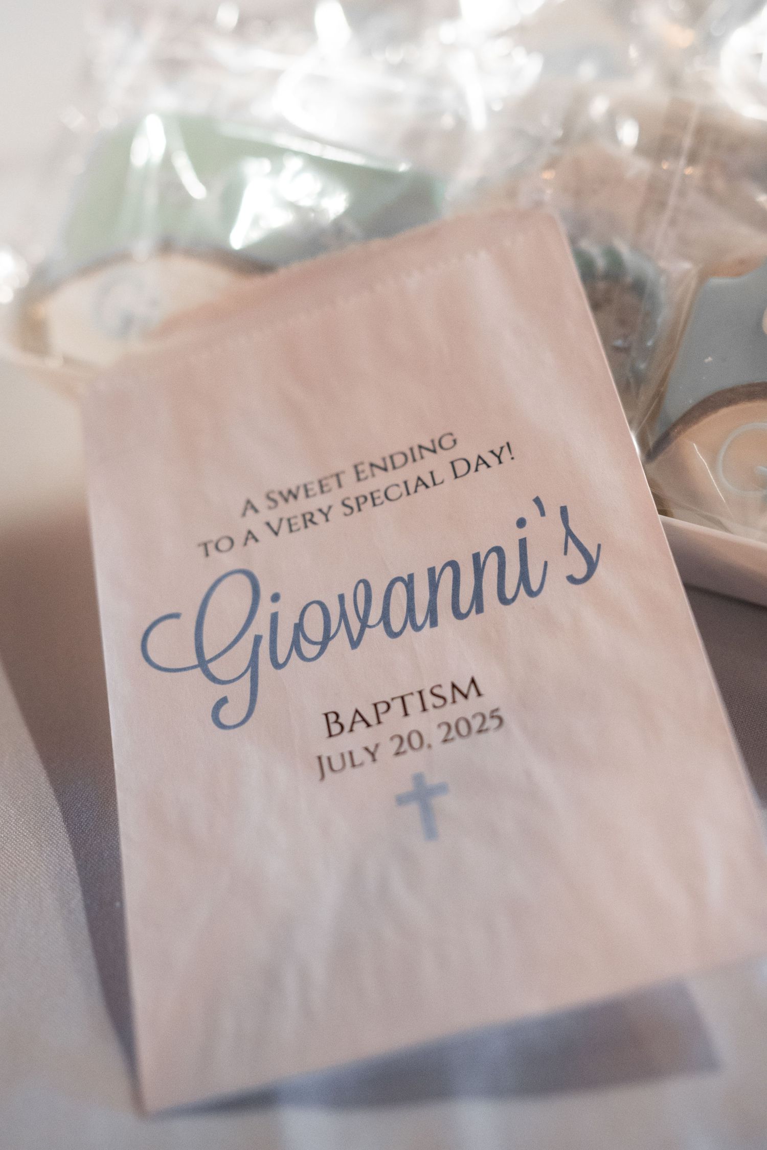Close-up shots of elegant baptism favor cards with blue script text showing the date July 20, 2023.