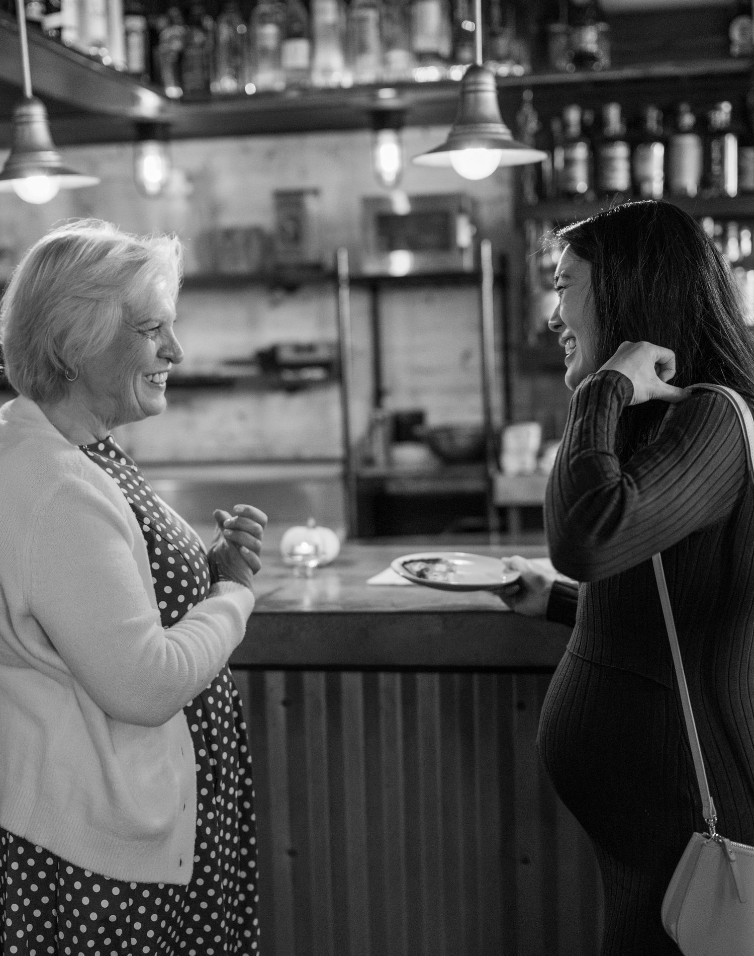 Black and white candid shots of people dancing and celebrating at a bar venue.