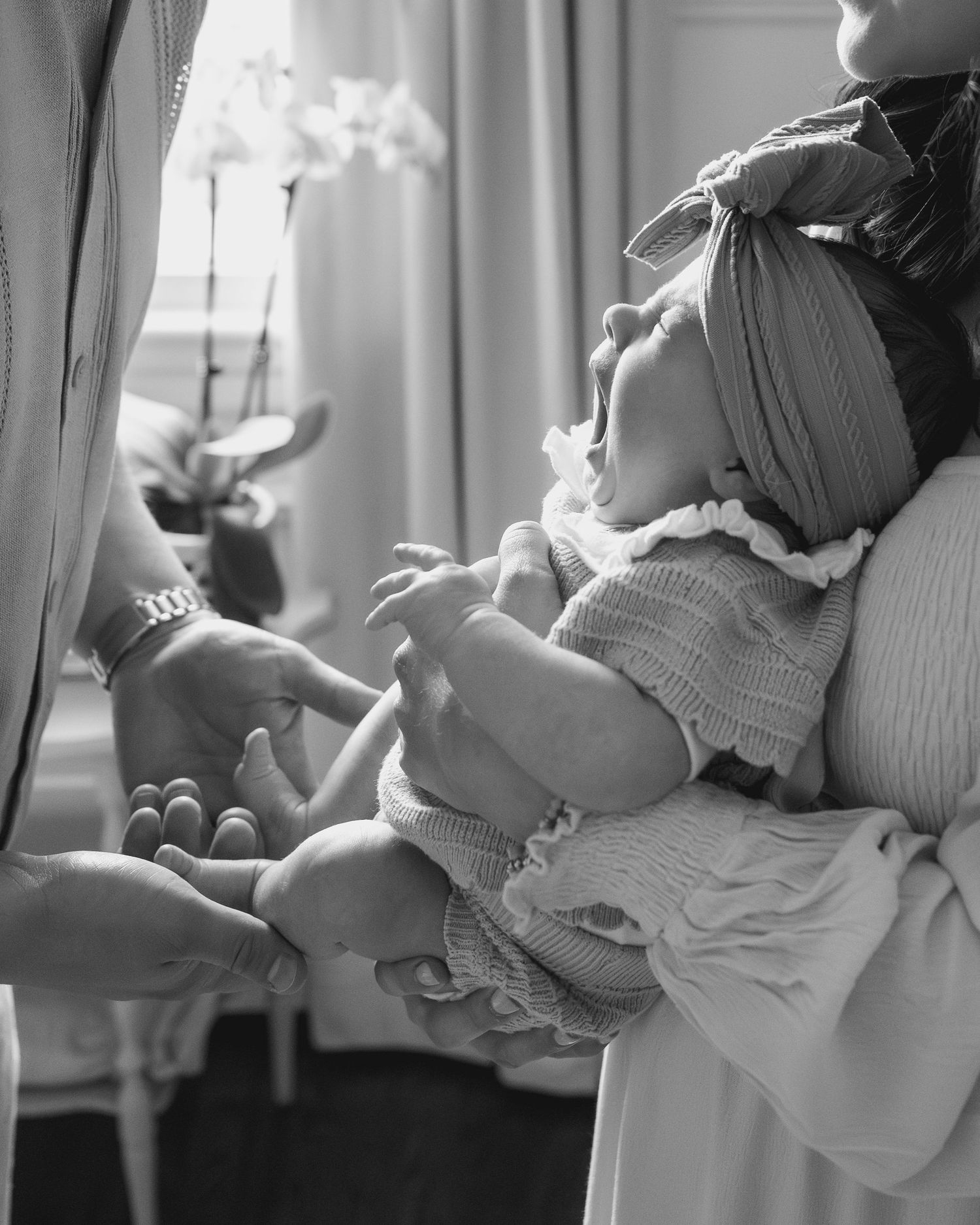 Black and white photo series showing tender moments between a parent and infant in natural light.