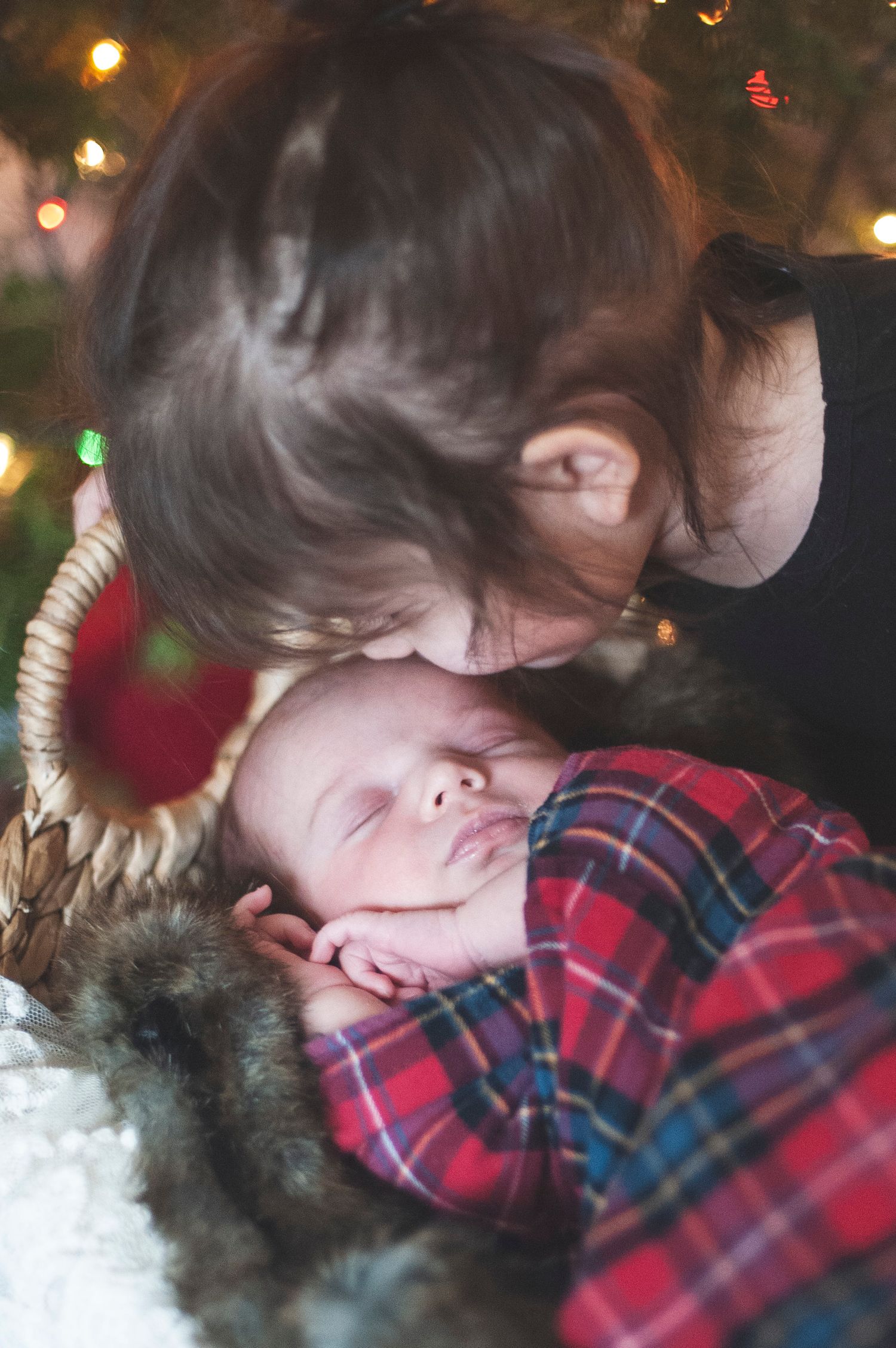 Cozy holiday scene with plaid blanket and twinkling lights in background.
