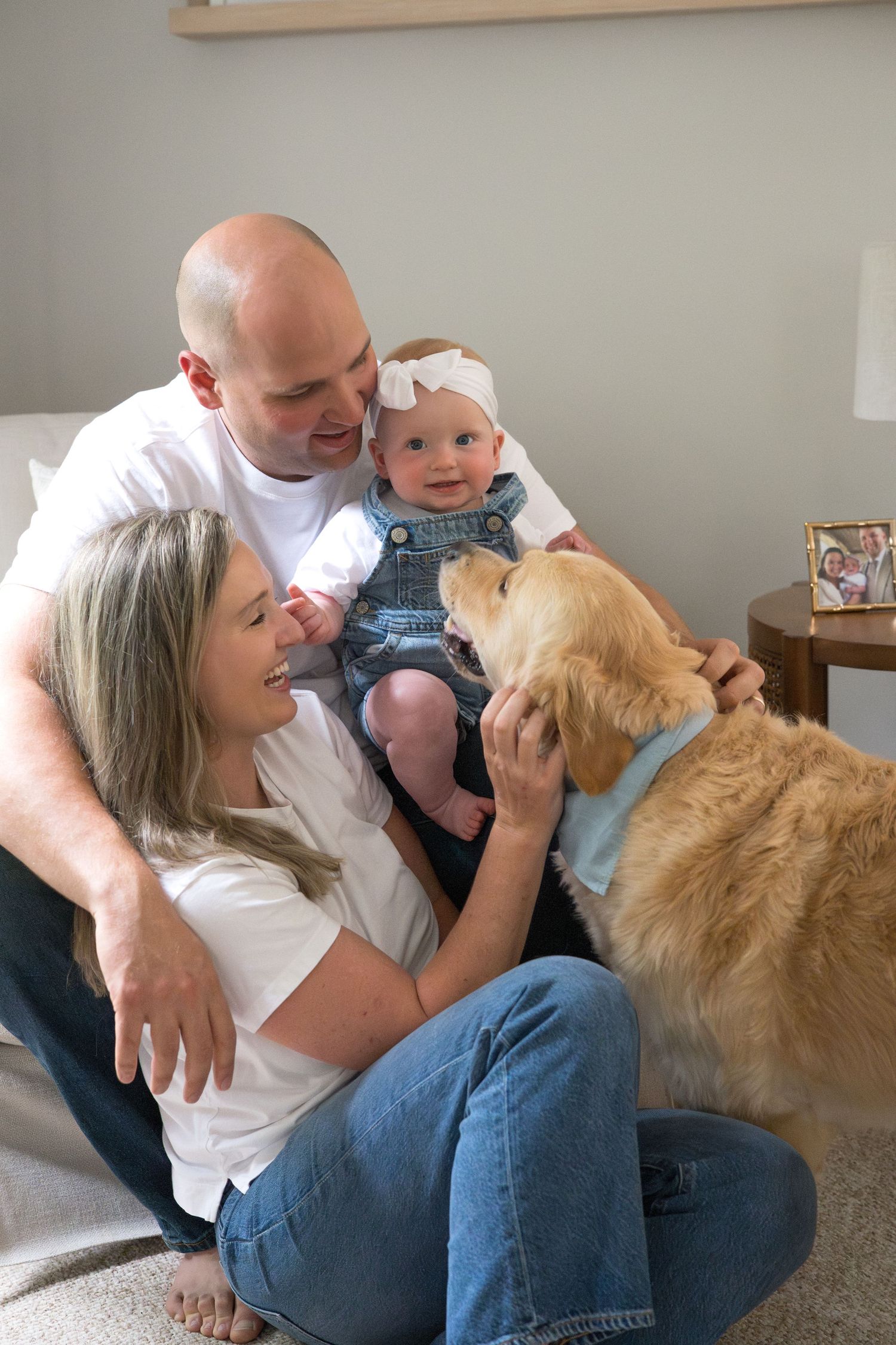 A family and their golden retriever sharing loving moments on a couch.