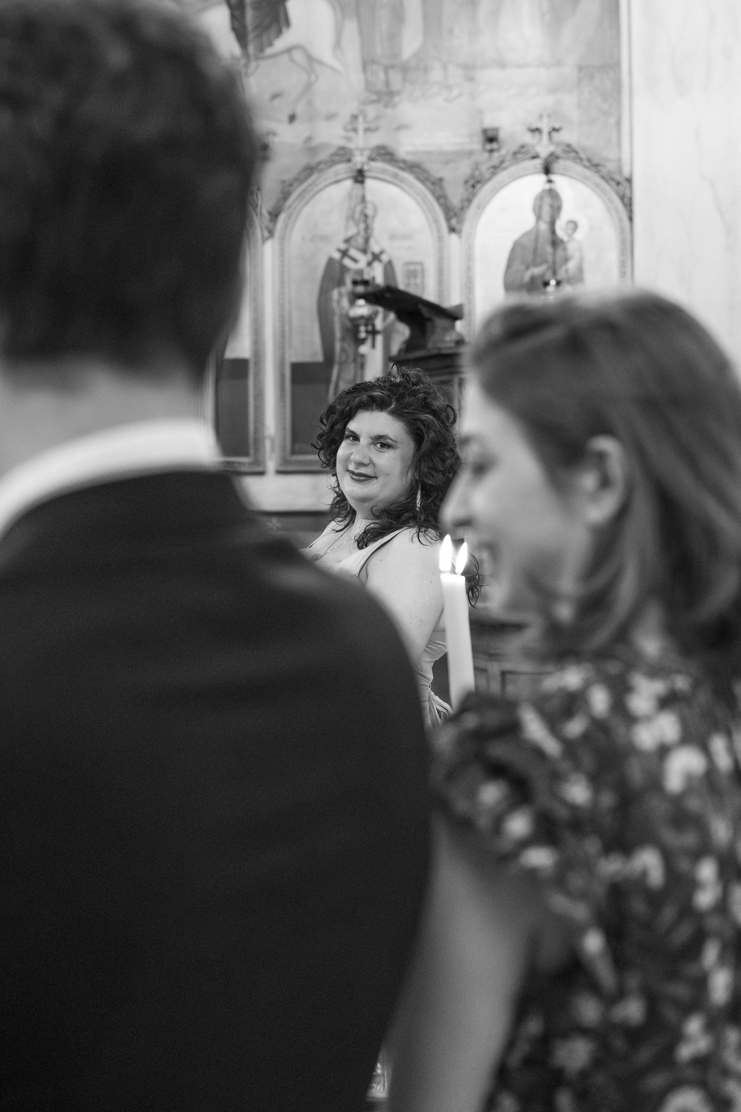 Black and white candid moments captured during a church ceremony with ornate architecture.