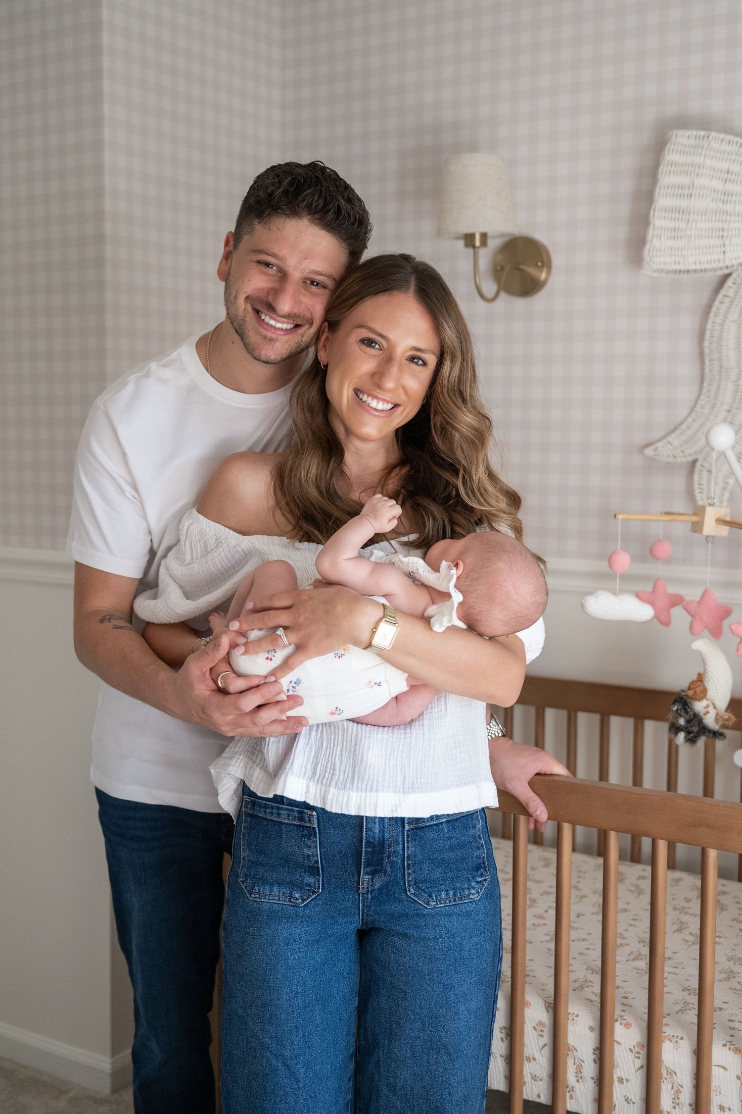 Intimate family moment in a nursery with white and gray decor.