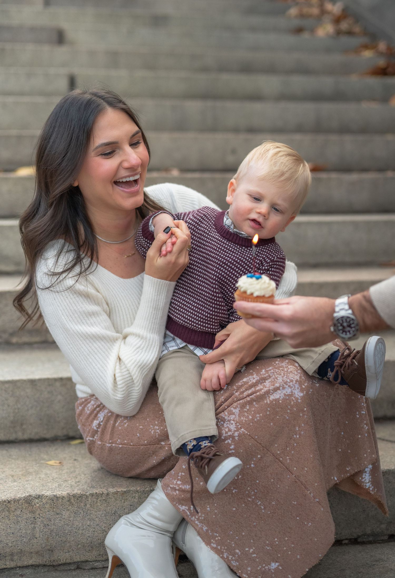 Family sitting on concrete steps sharing joyful moments together.