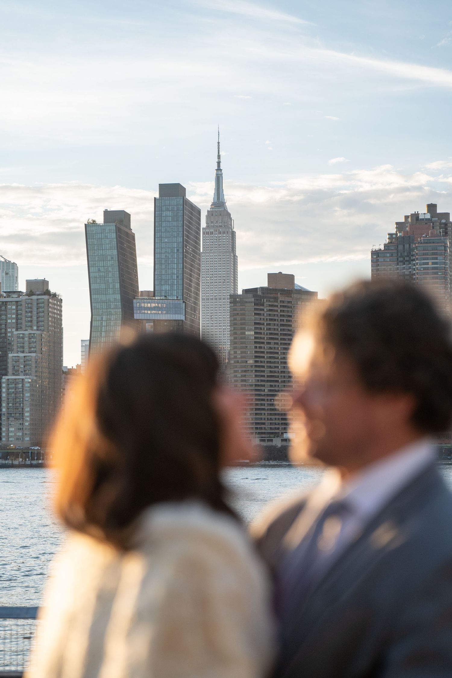 New York City skyline serves as backdrop for wedding party silhouettes at sunset.