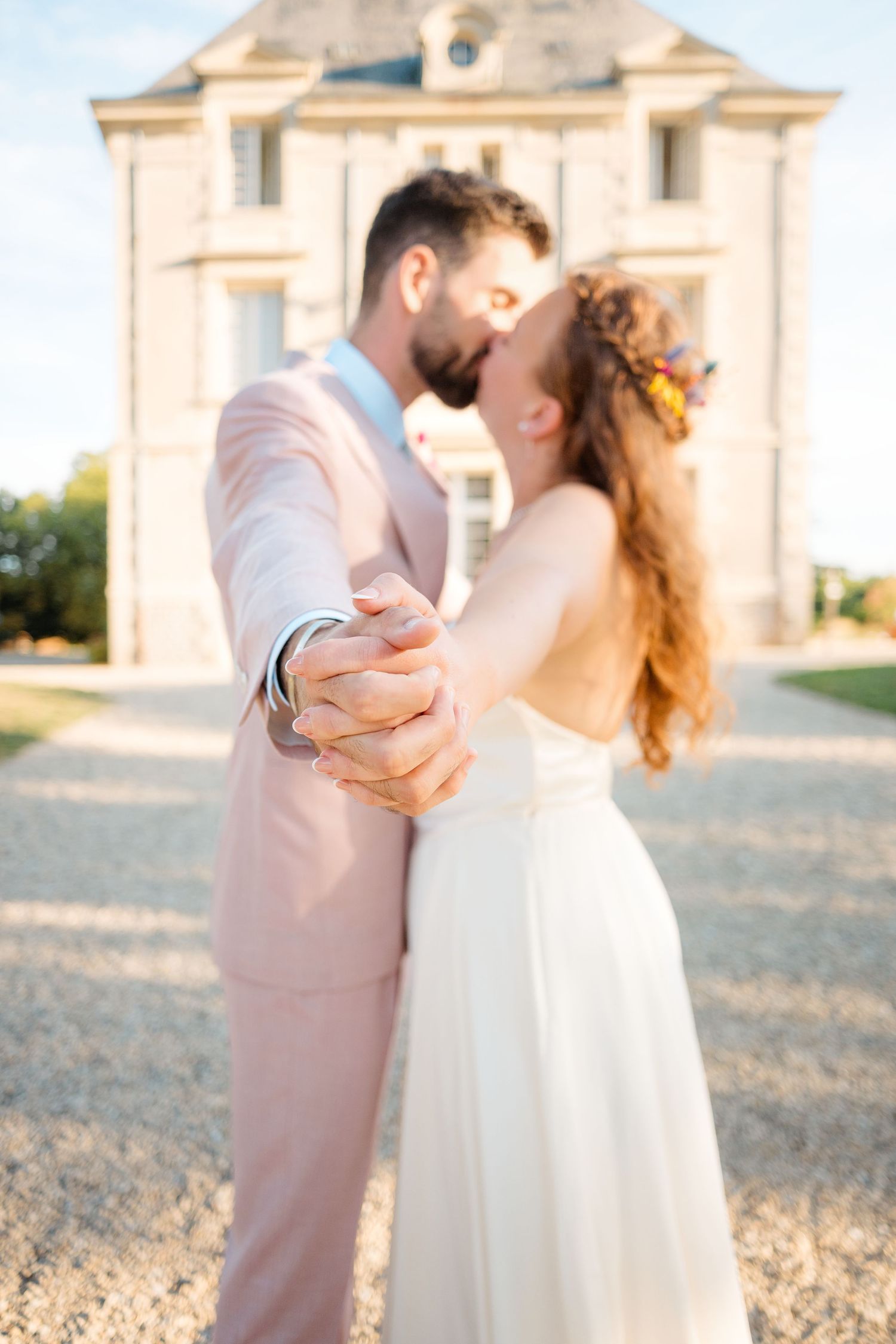 Couple de mariés amoureux devant un château, photo lumineuse et romantique – photographe mariage Nantes - Cop-choux