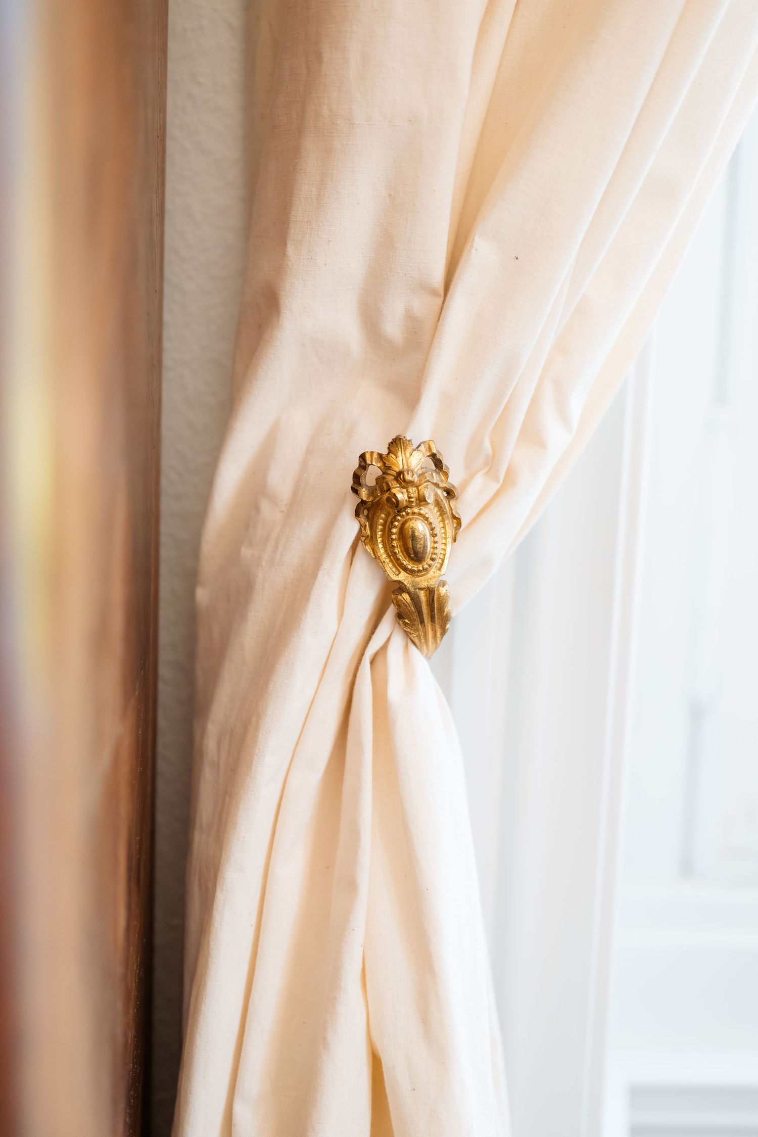 Détail raffiné d’un rideau doré au château du coing - mariage en Loire-Atlantique.