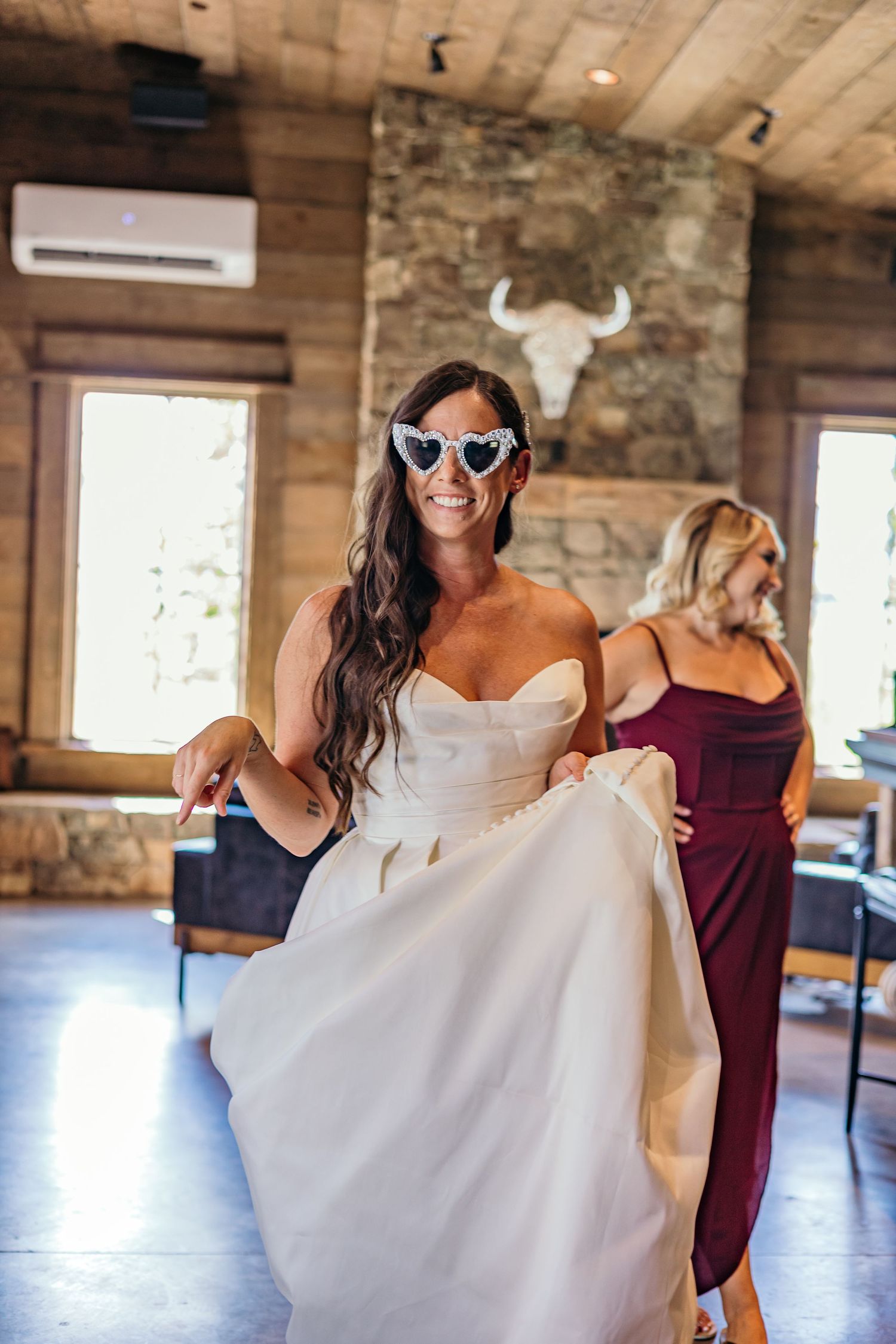 Wedding dress preparations in a rustic wooden interior with stone walls.