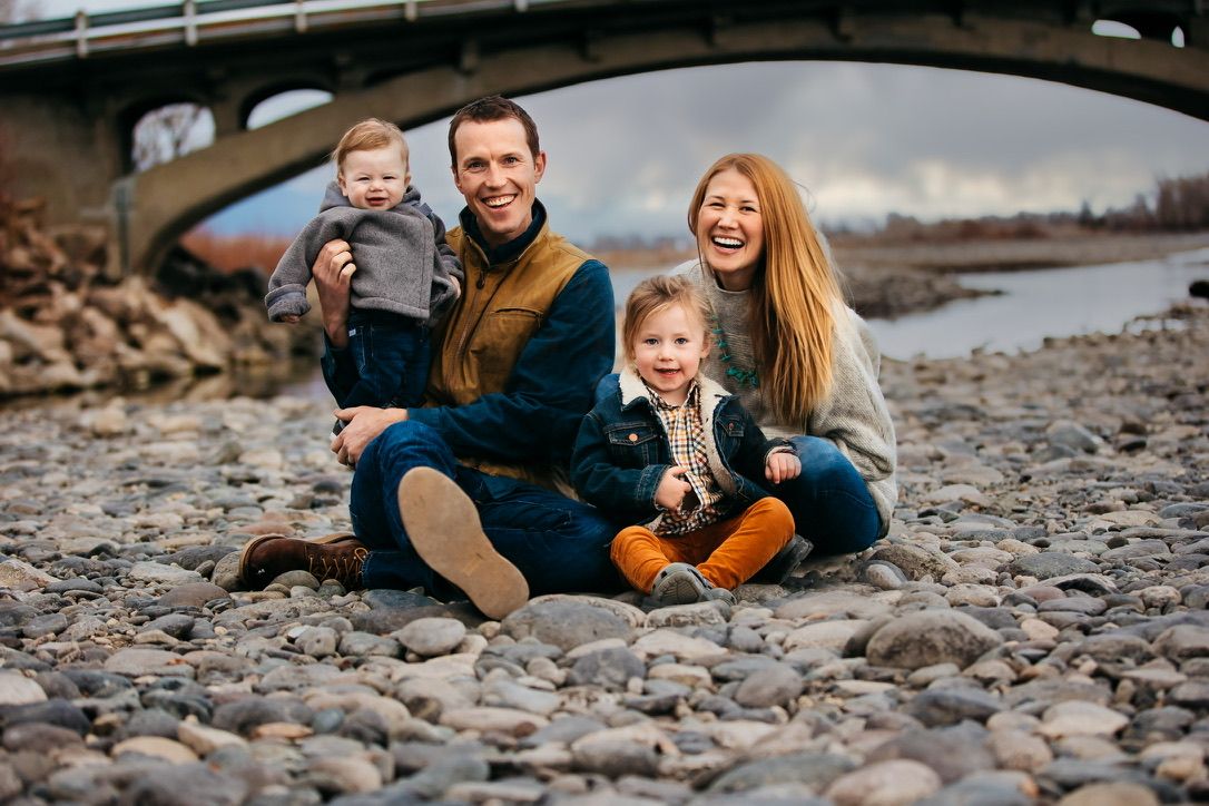 Family enjoying time together on a rocky beach shoreline.