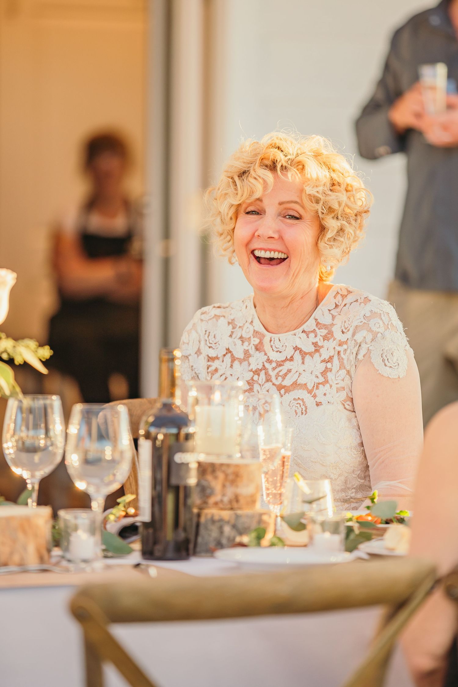 Wedding guests enjoying dinner and conversation at an elegant indoor reception.