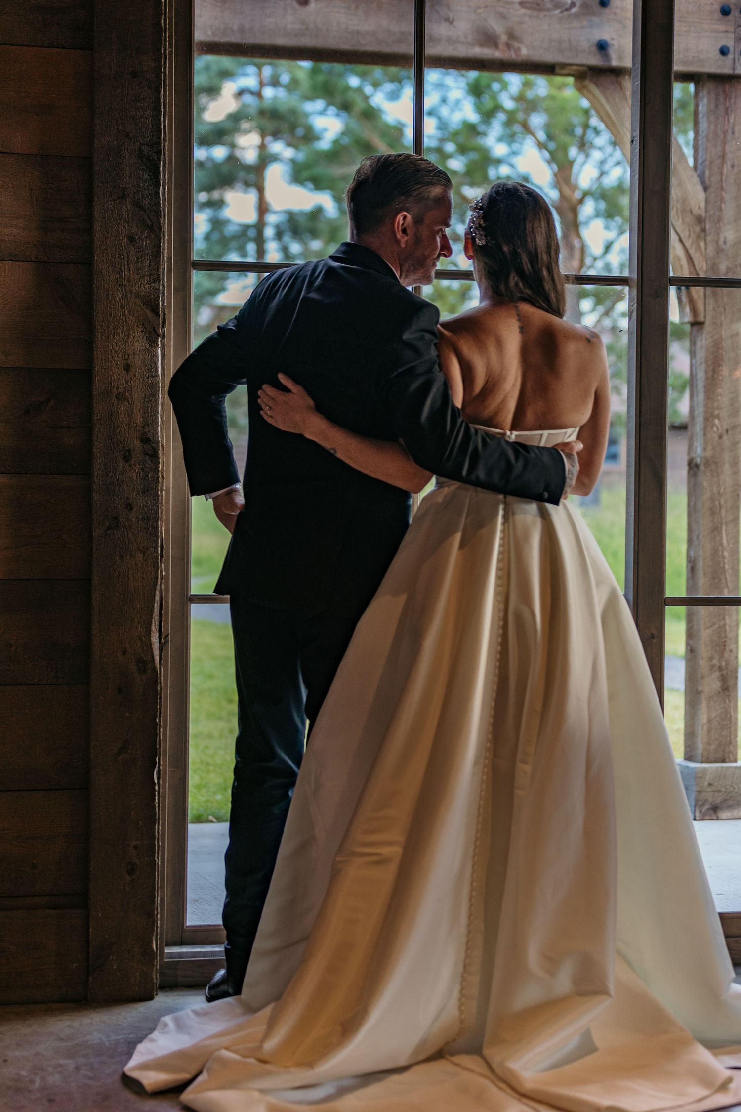Romantic dance between newlyweds in a rustic wooden cabin setting.