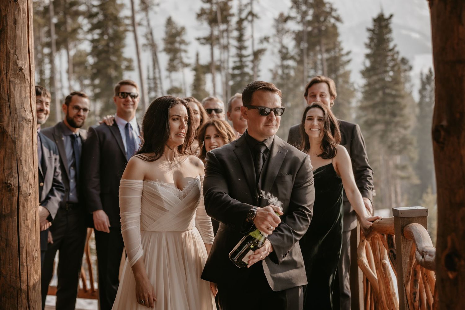 Wedding ceremony in progress at rustic wooden venue with snow-covered landscape.