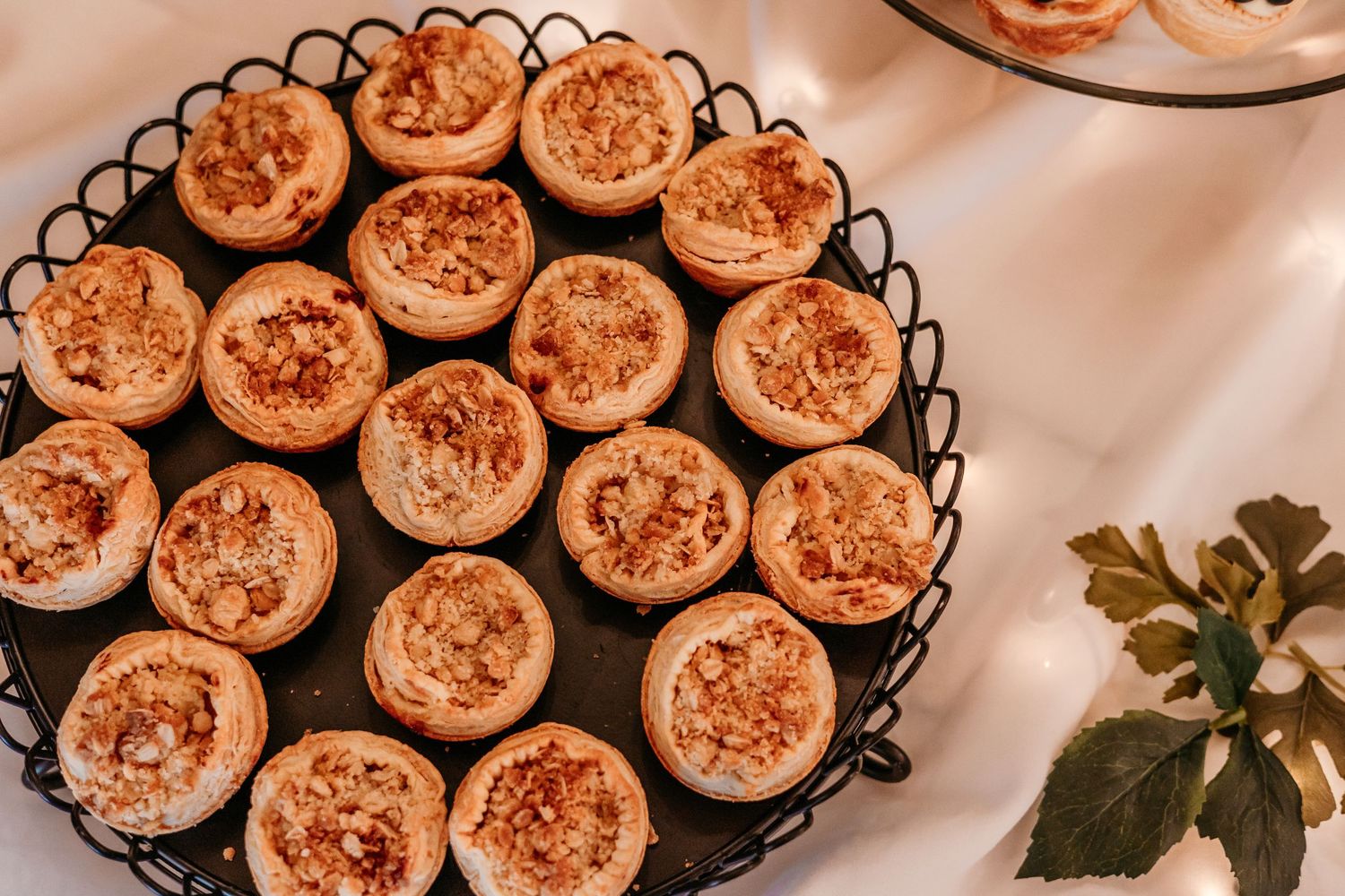 Artfully arranged dessert display of mini tarts on black serving platters.