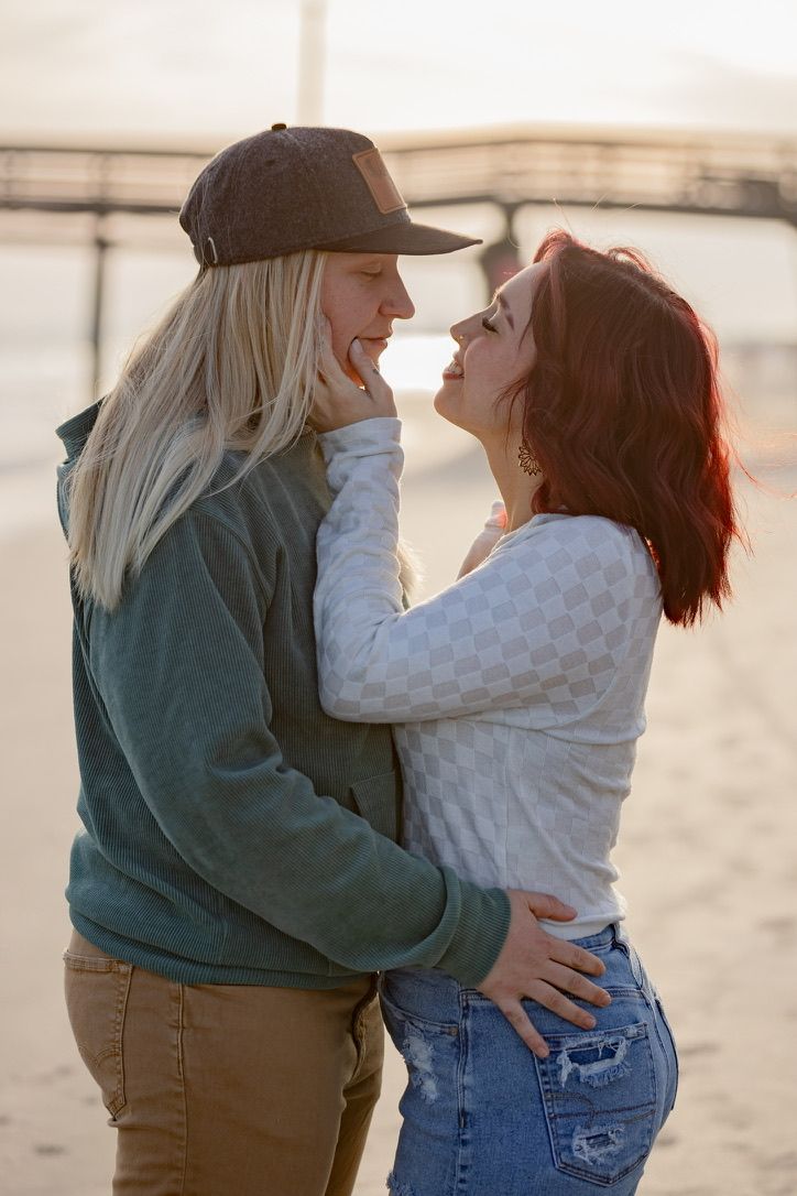 Intimate moment between couple embracing on beach at sunset.