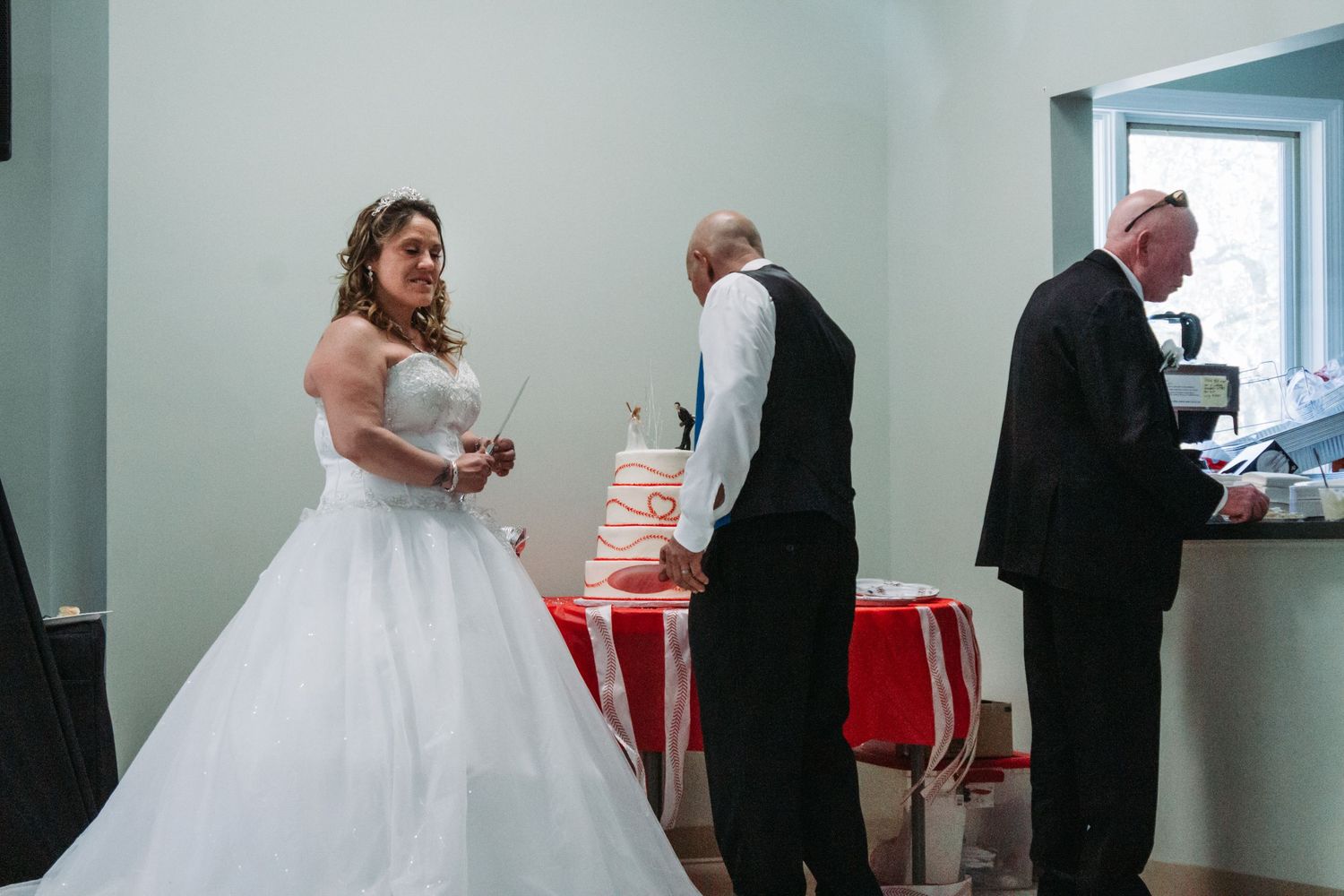Wedding reception scene with guests gathering around a red-accented buffet table.