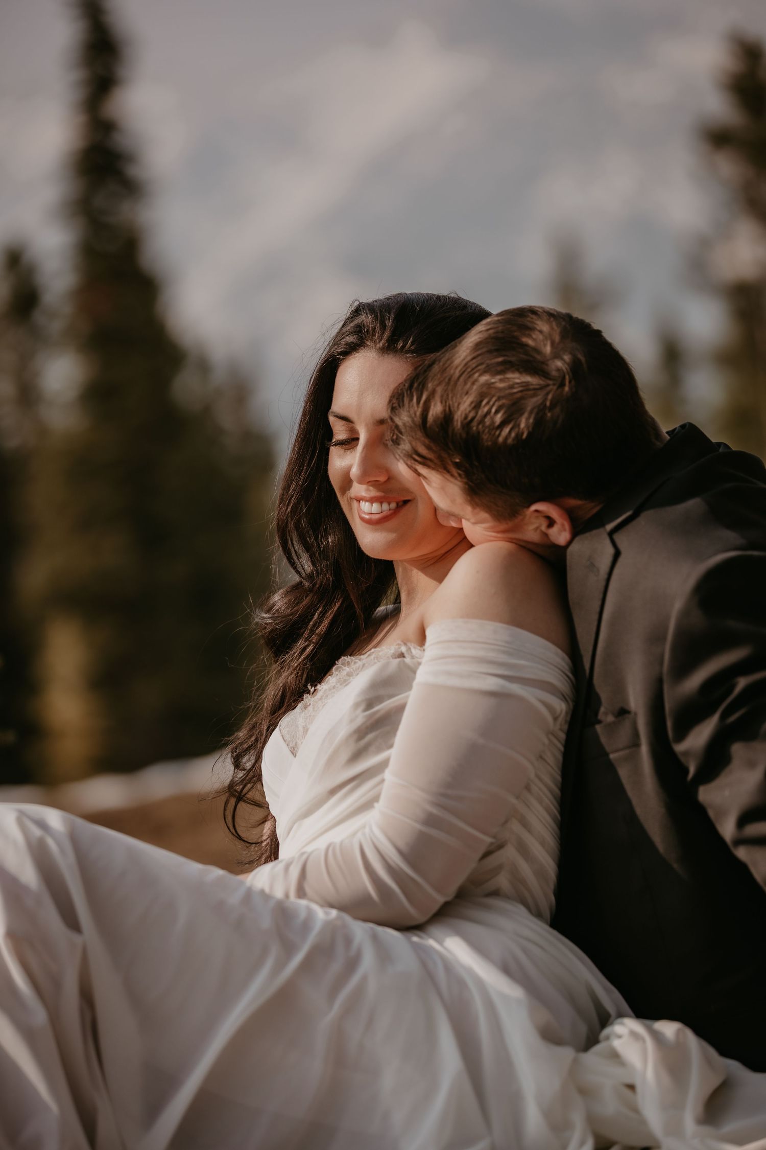 Romantic couple embracing in a tender moment during their mountain wedding.