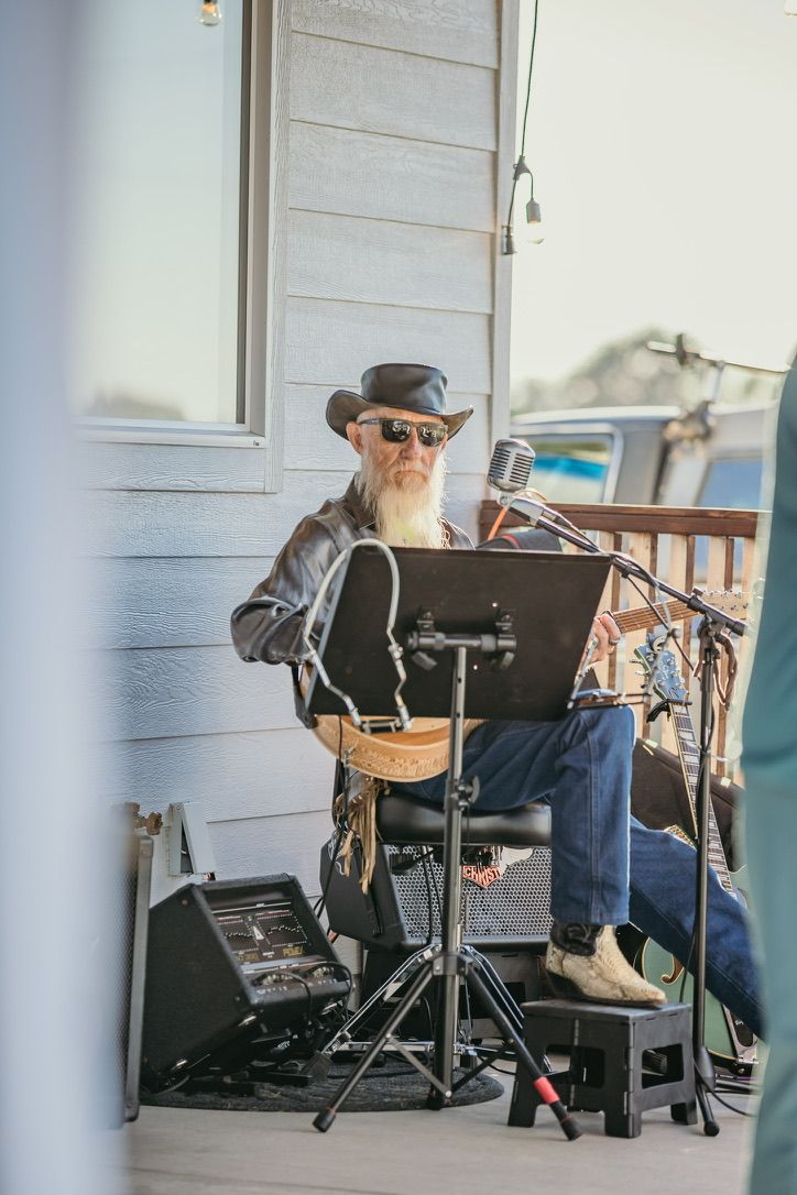 Musician performing at outdoor venue with music stand and equipment setup.