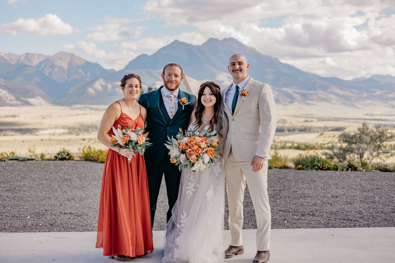 Wedding party members posing together with dramatic mountain landscape behind them.