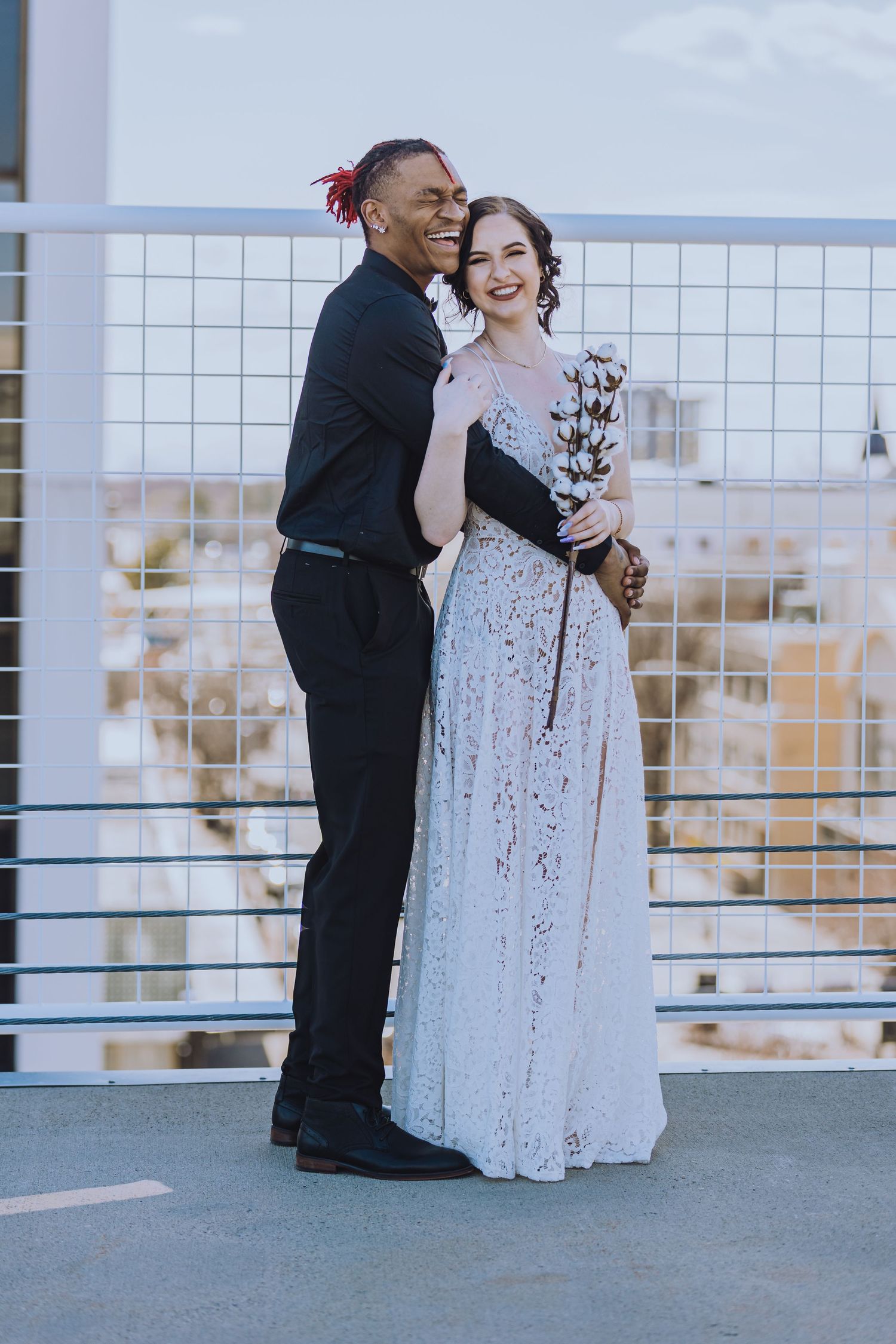 A couple shares a romantic moment on a rooftop during their wedding photoshoot.