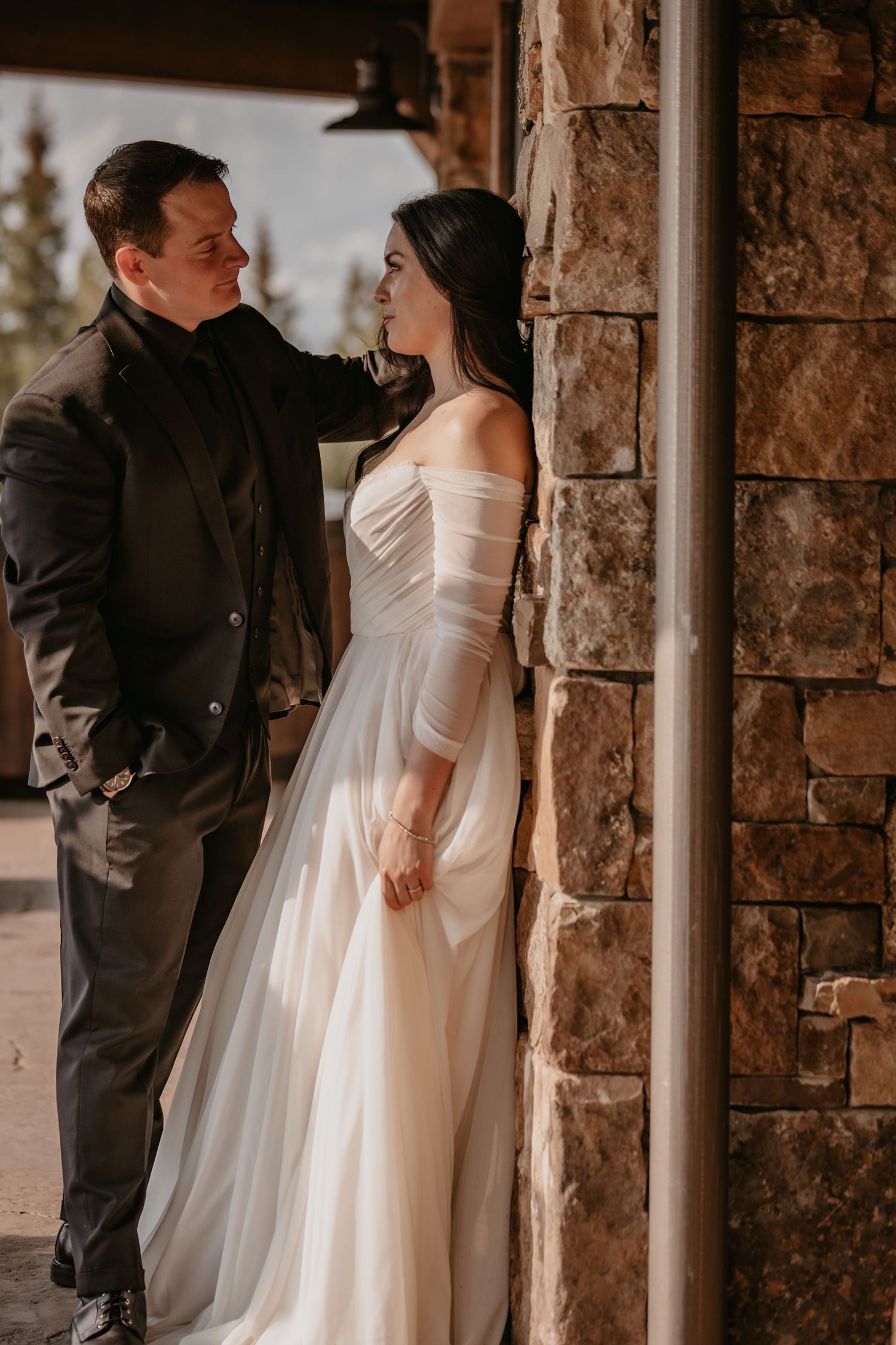 Wedding couple sharing intimate moment between stone columns.