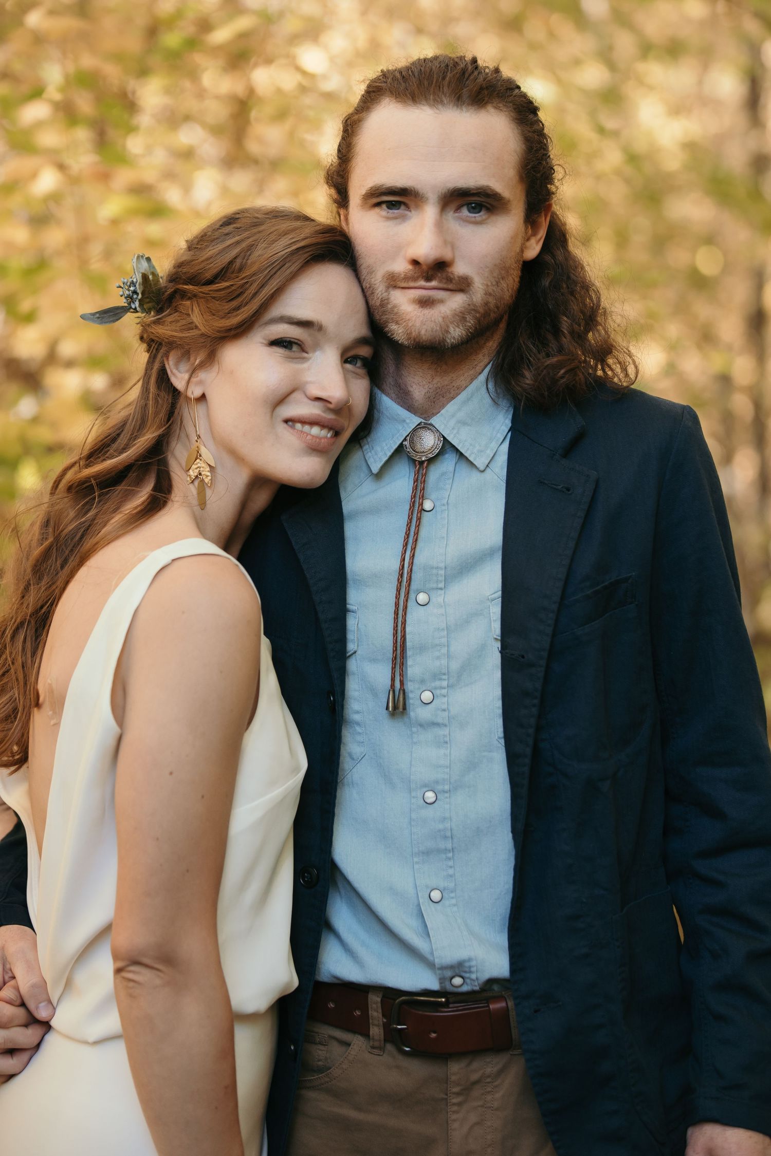 Candid moments between couple in formal wear against golden autumn background.