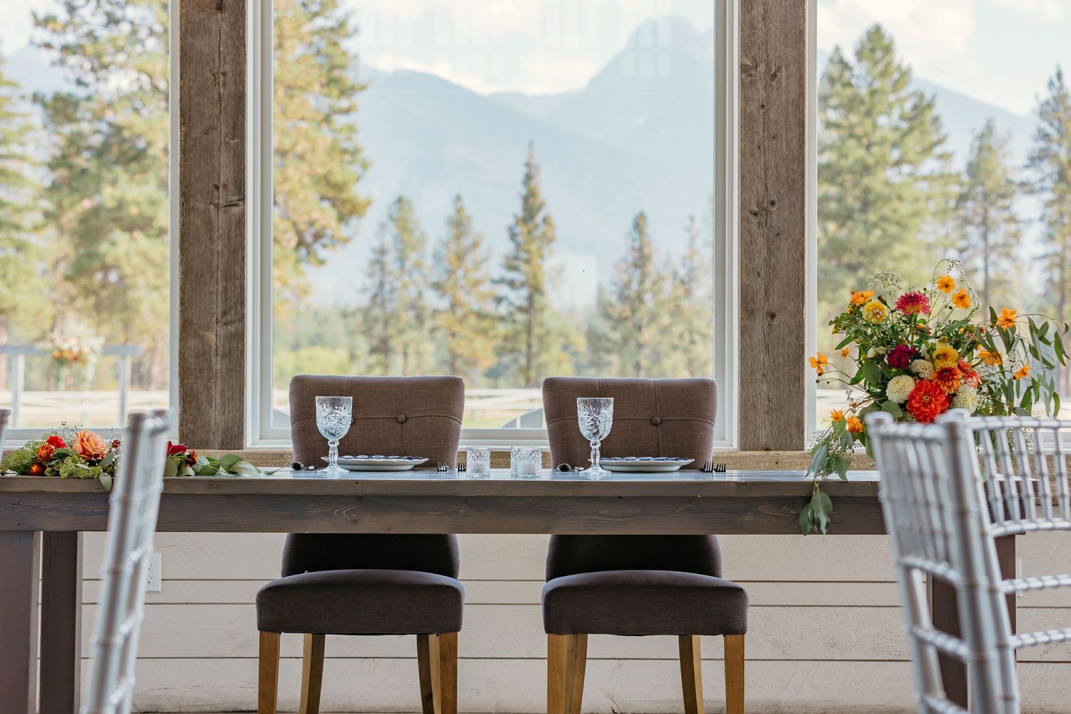 Elegant mountain view dining setup with tables arranged under a covered patio area.