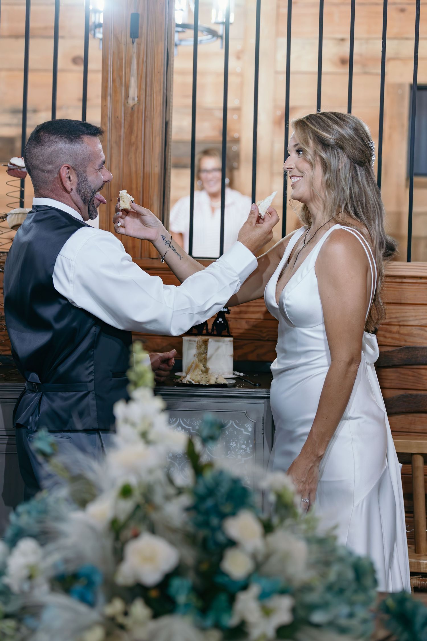 Celebratory dancing and movement captured during a rustic indoor wedding reception.