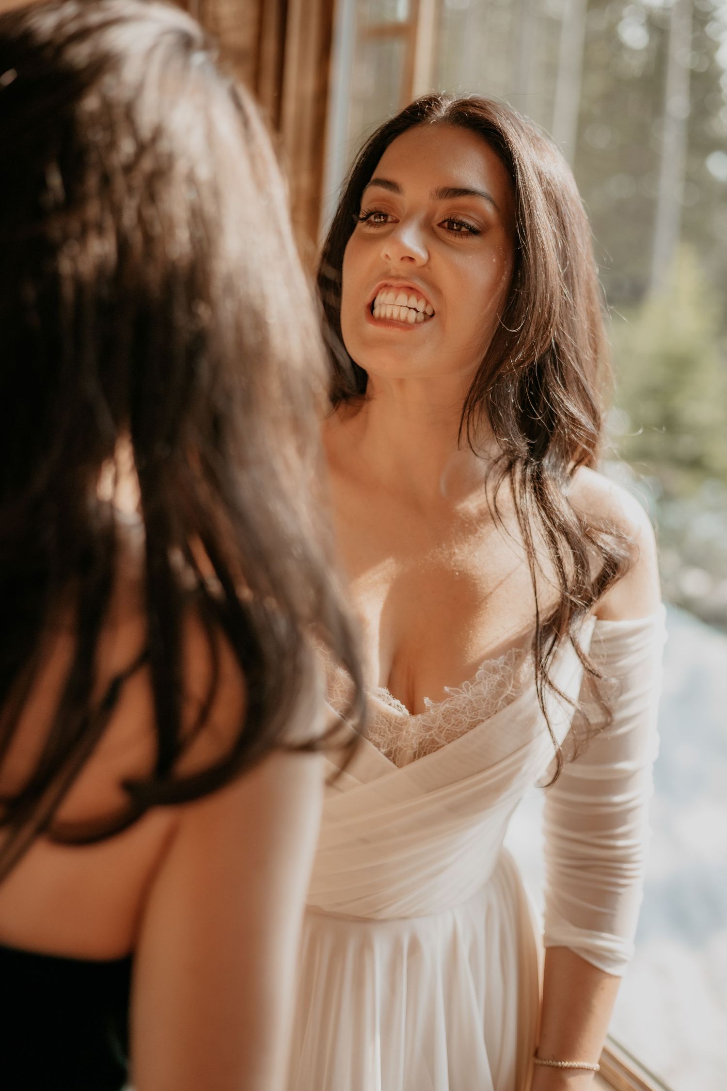 Candid bridal portrait showing joyful laughter in natural window light.