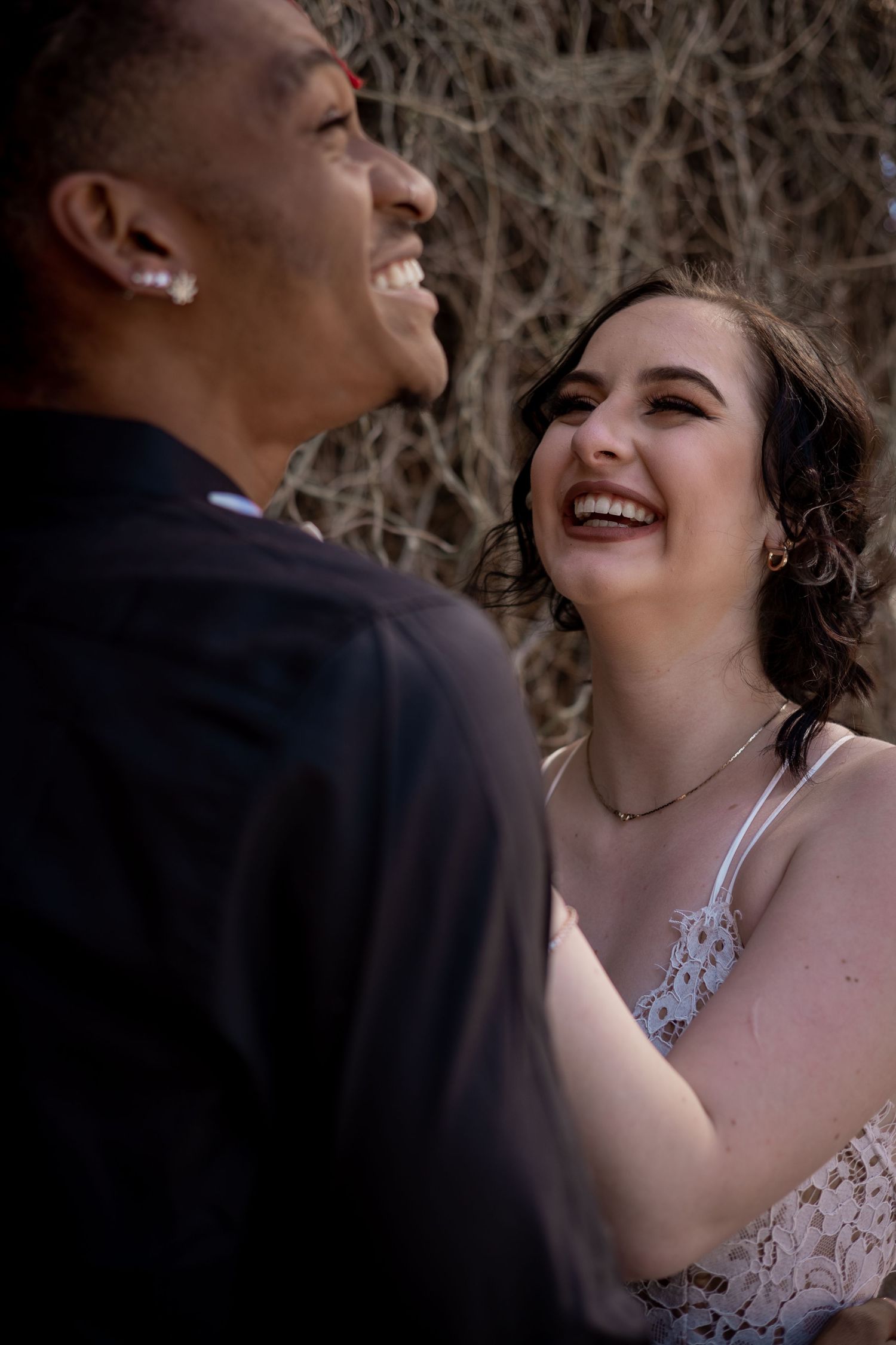 A candid moment of shared laughter between a couple in formal attire.