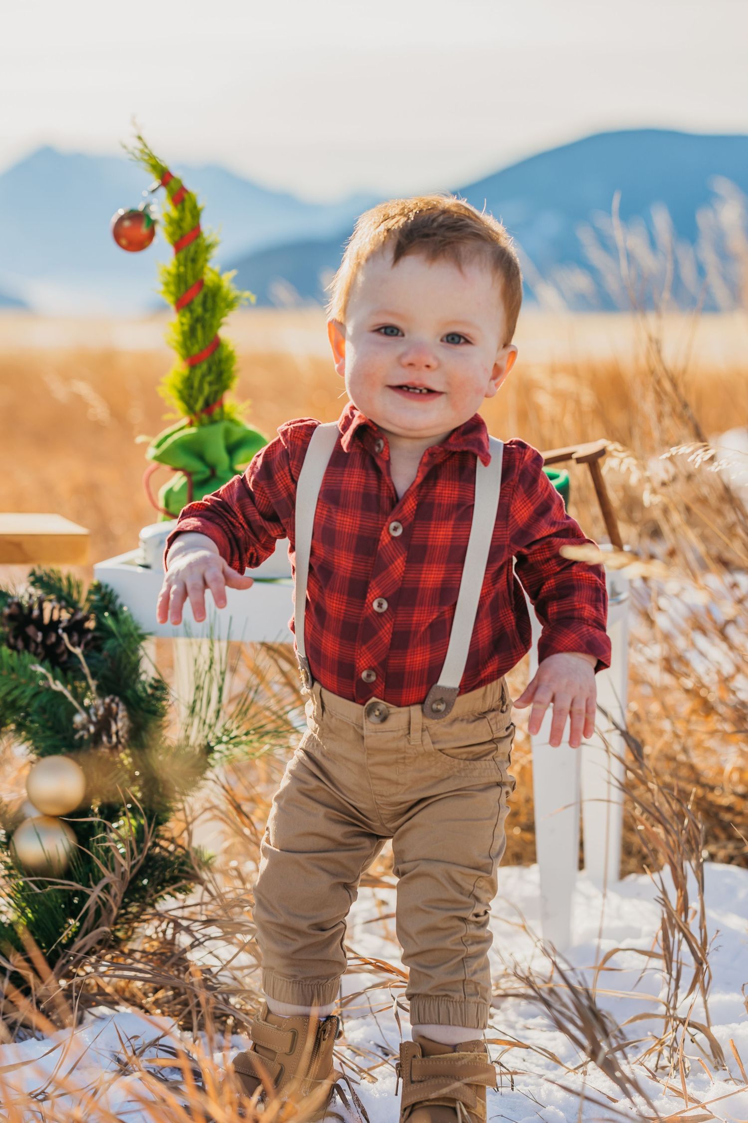 Red plaid shirt and khaki suspenders outfit in autumn field setting.