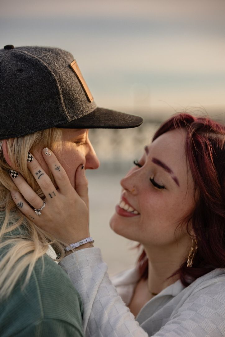 An intimate close-up moment between a couple wearing casual attire during golden hour.