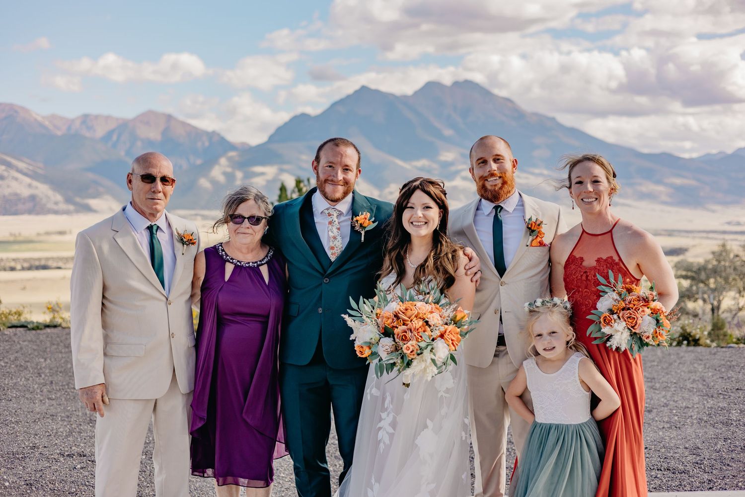 Wedding party group photos with mountain backdrop and colorful attire.