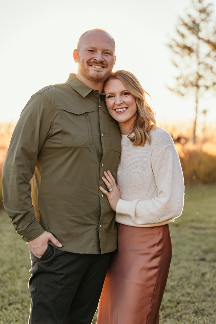 Couple sharing intimate moment during outdoor sunset photoshoot.