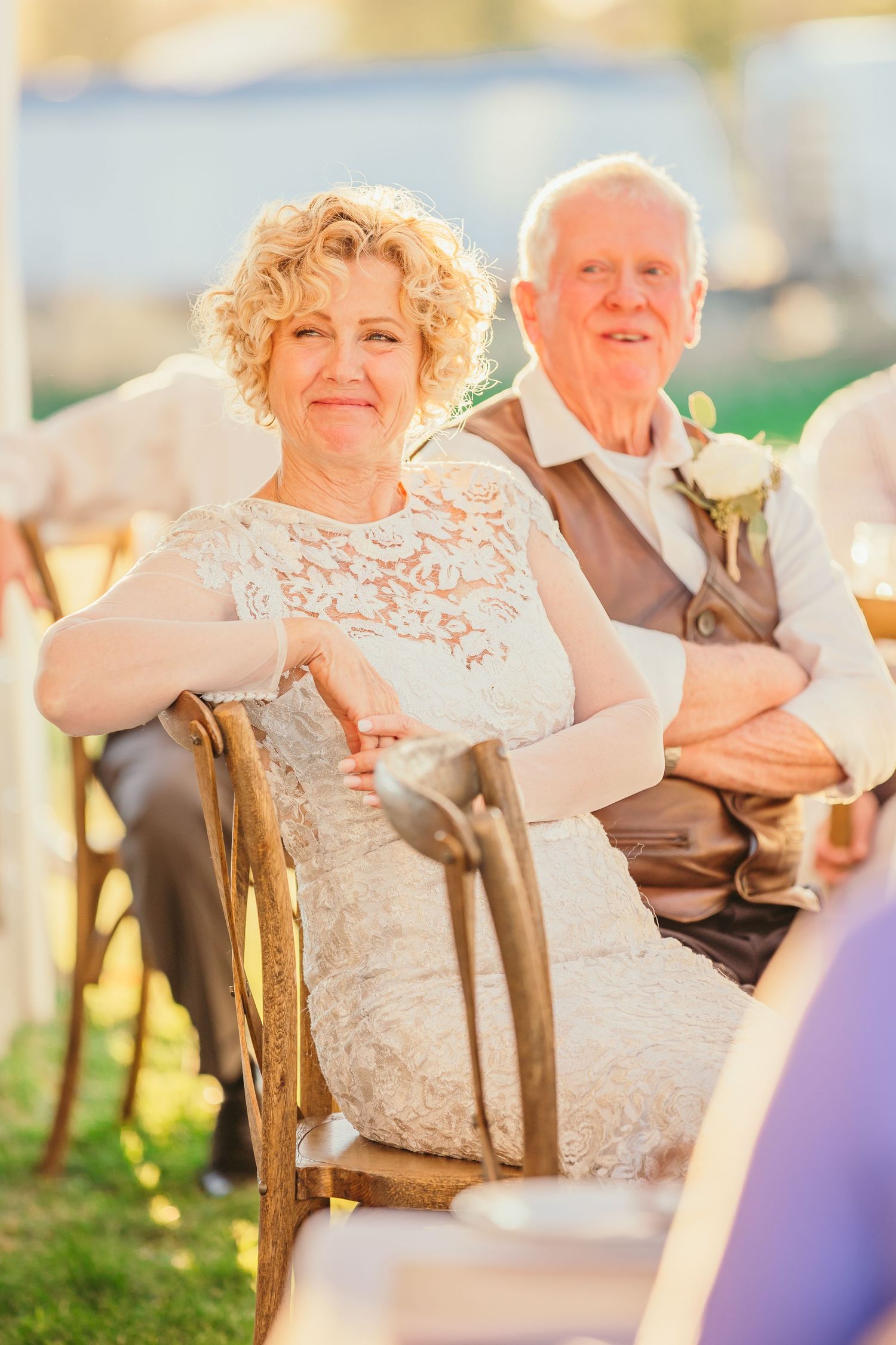 Wedding guests seated at outdoor tables during sunset celebration.