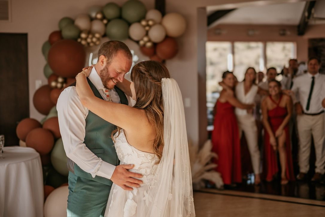 A romantic first dance moment at a wedding reception with balloon arch decor.