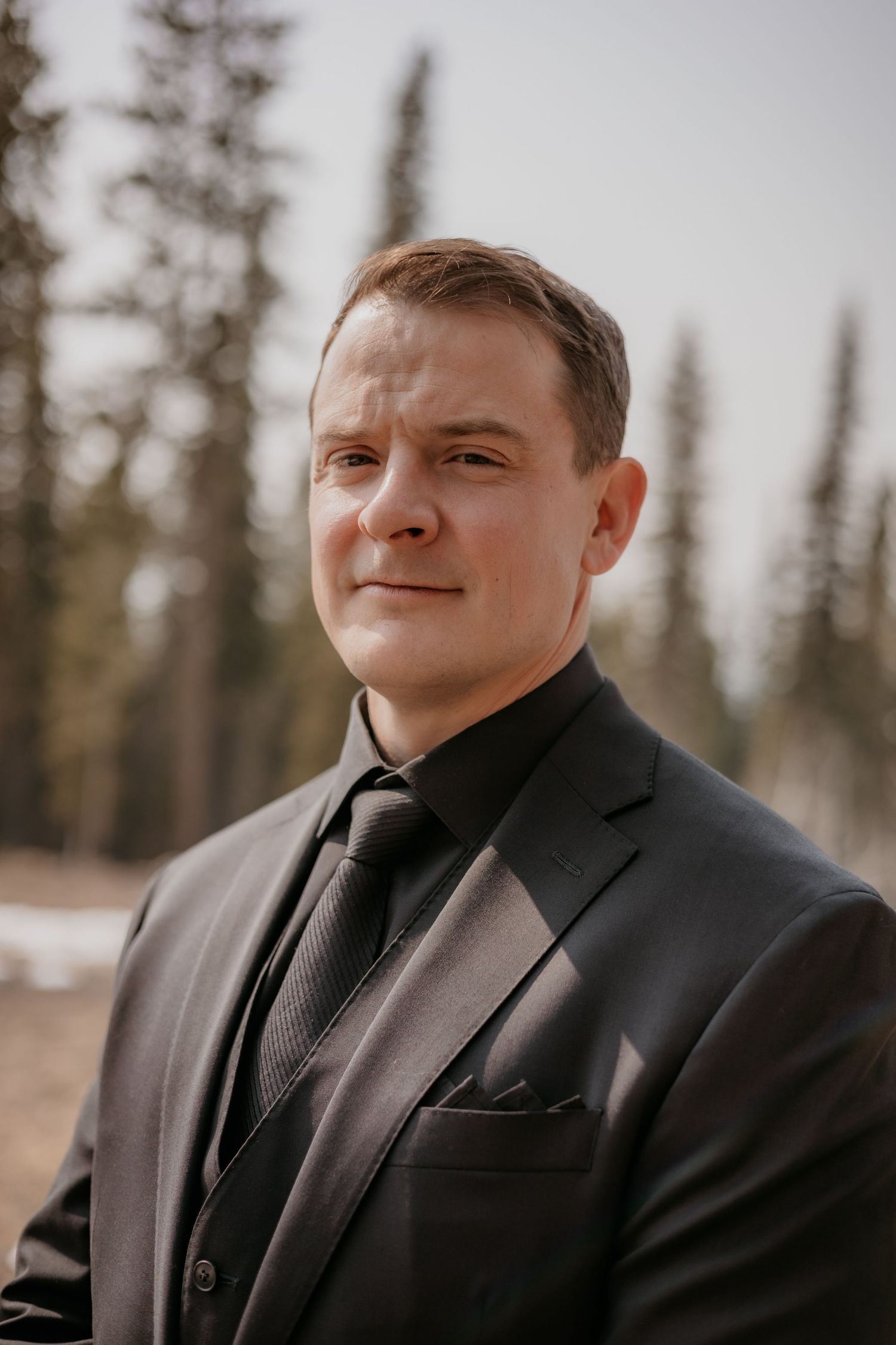 Portrait sequence against snowy winter background wearing formal black suit.