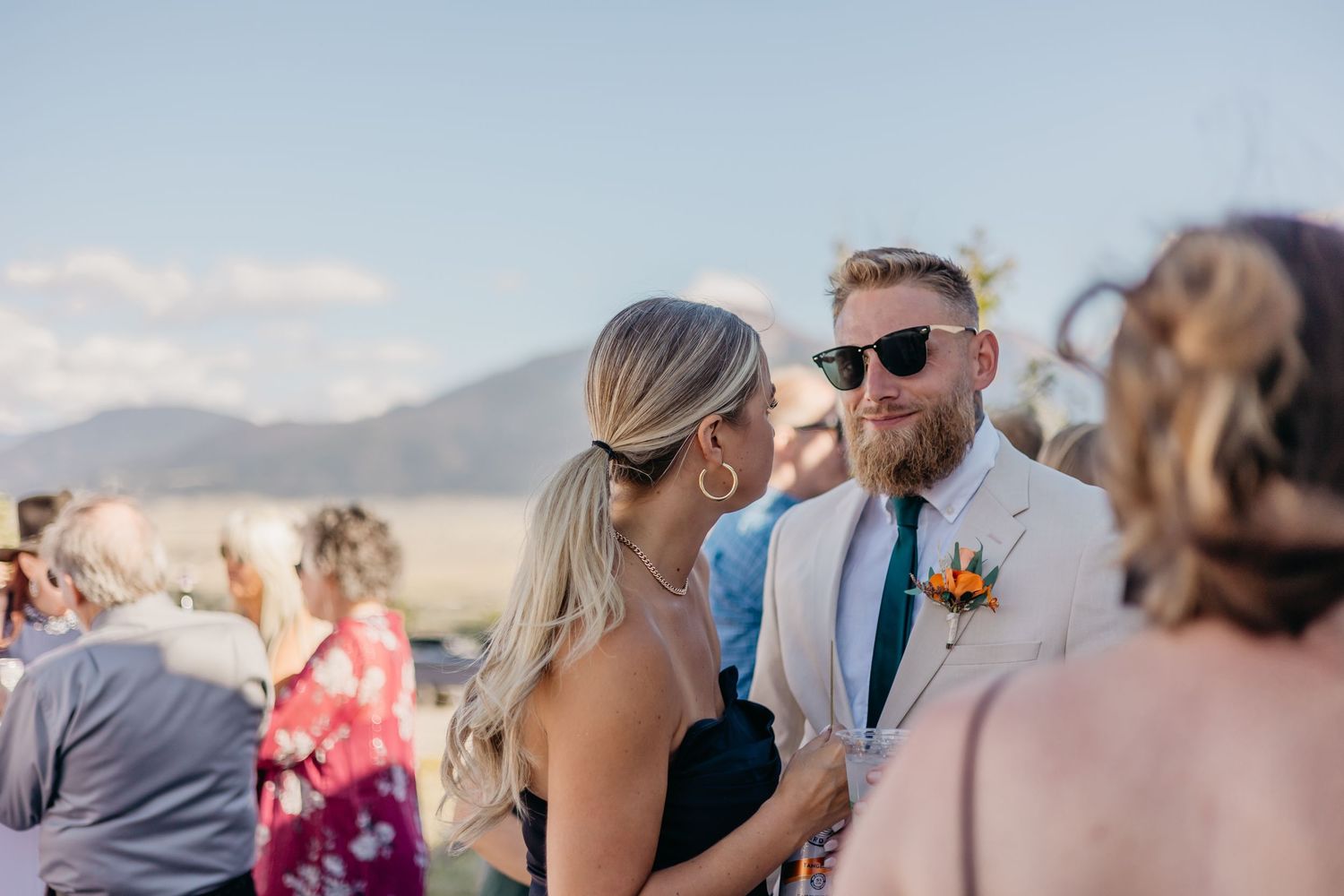 Wedding guests enjoy a scenic outdoor celebration with mountain views in the background.
