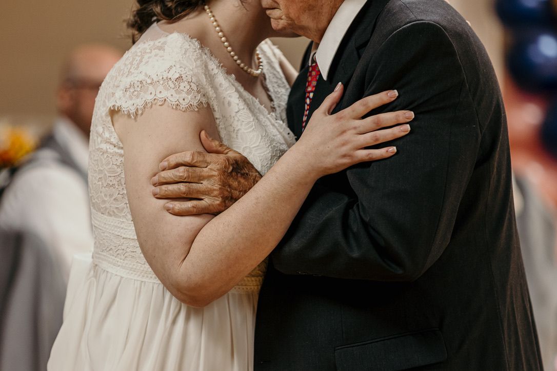 An intimate embrace captured during a wedding ceremony moment.