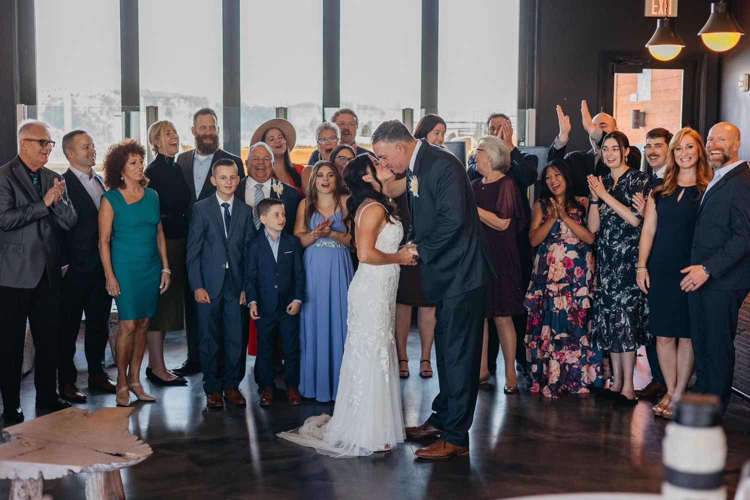 Indoor wedding reception with guests mingling in formal attire.