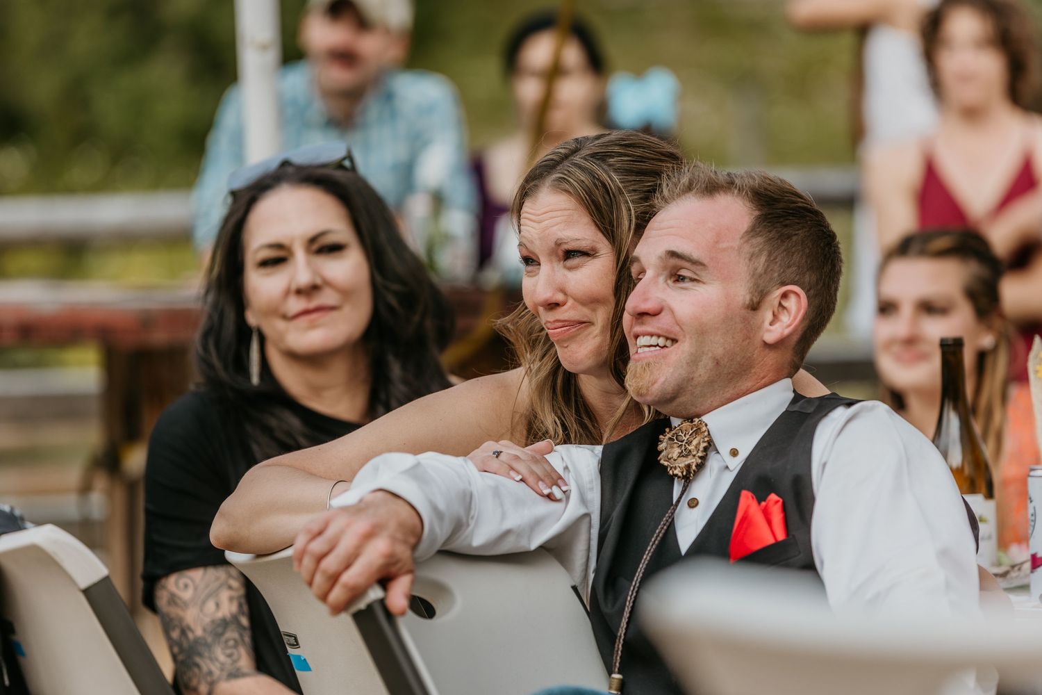 Wedding party smiles and laughs during outdoor celebration.
