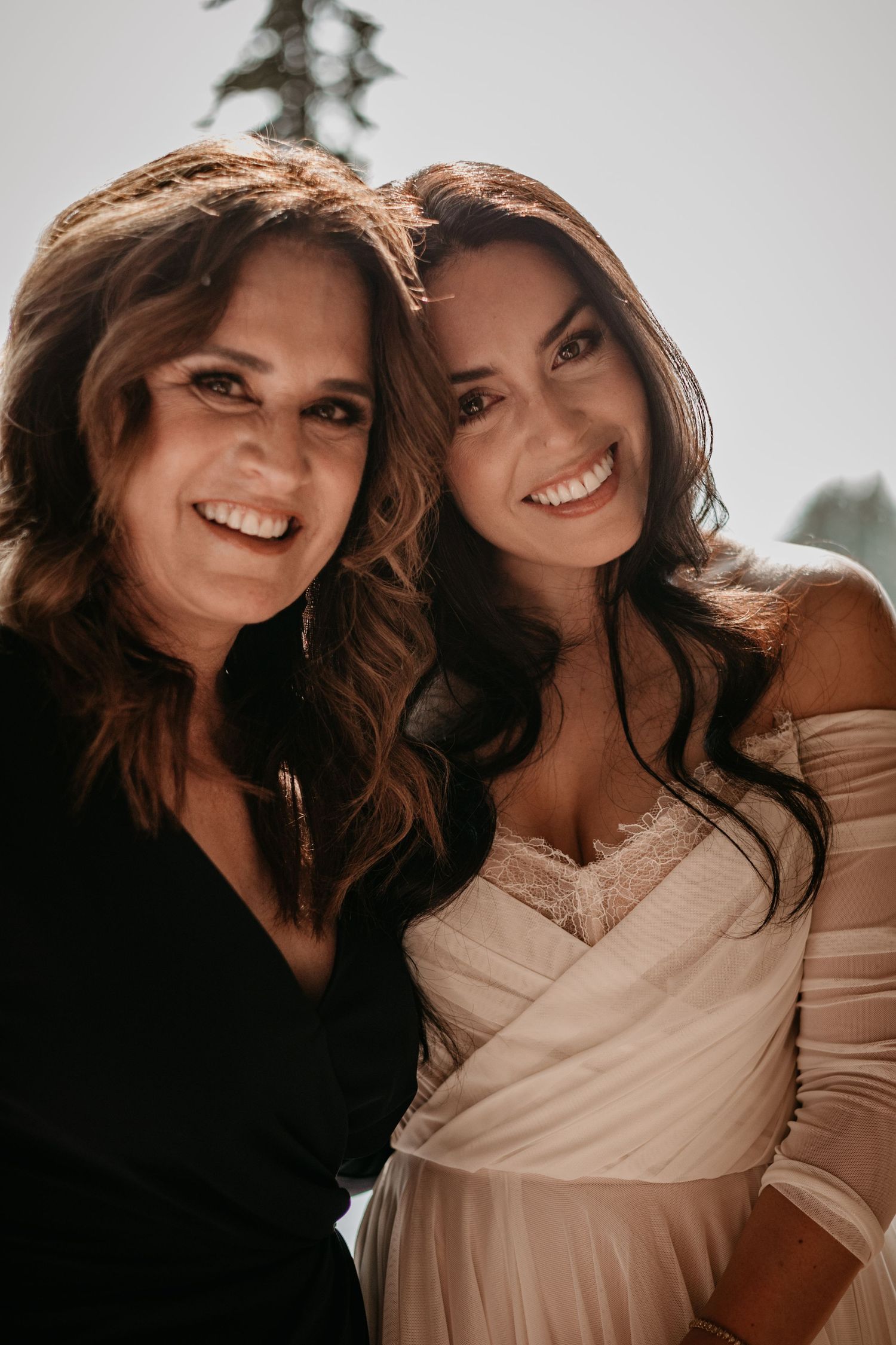 Close up portrait of two people smiling together in warm lighting.
