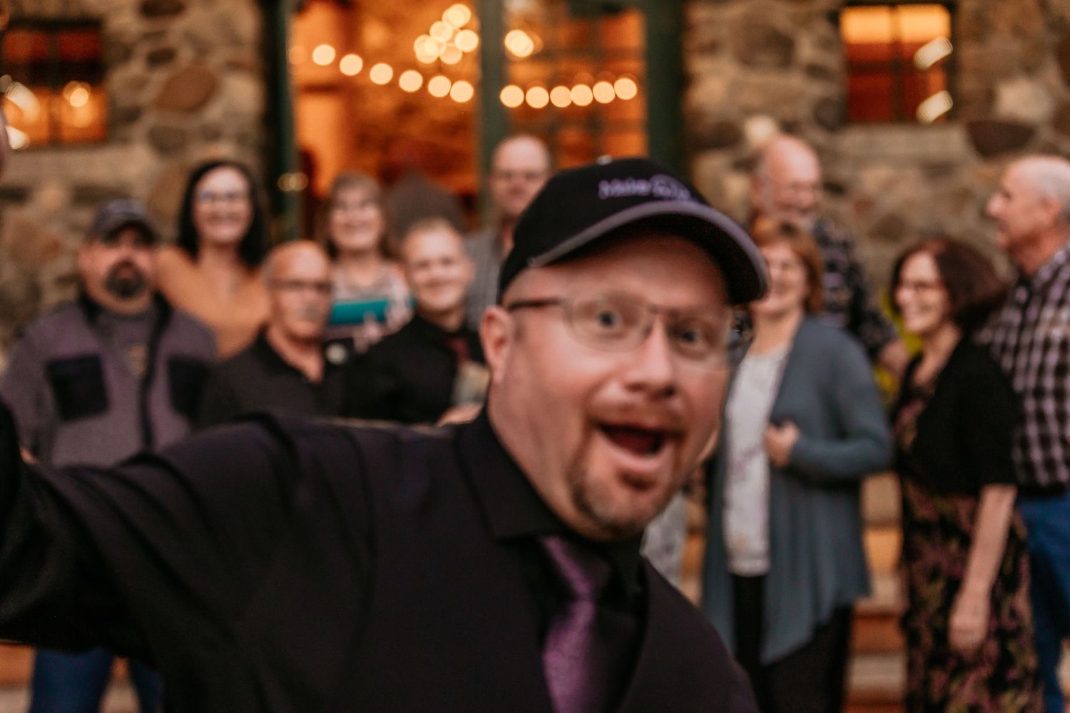 Wedding reception venue decorated with warm string lights and rustic decor.