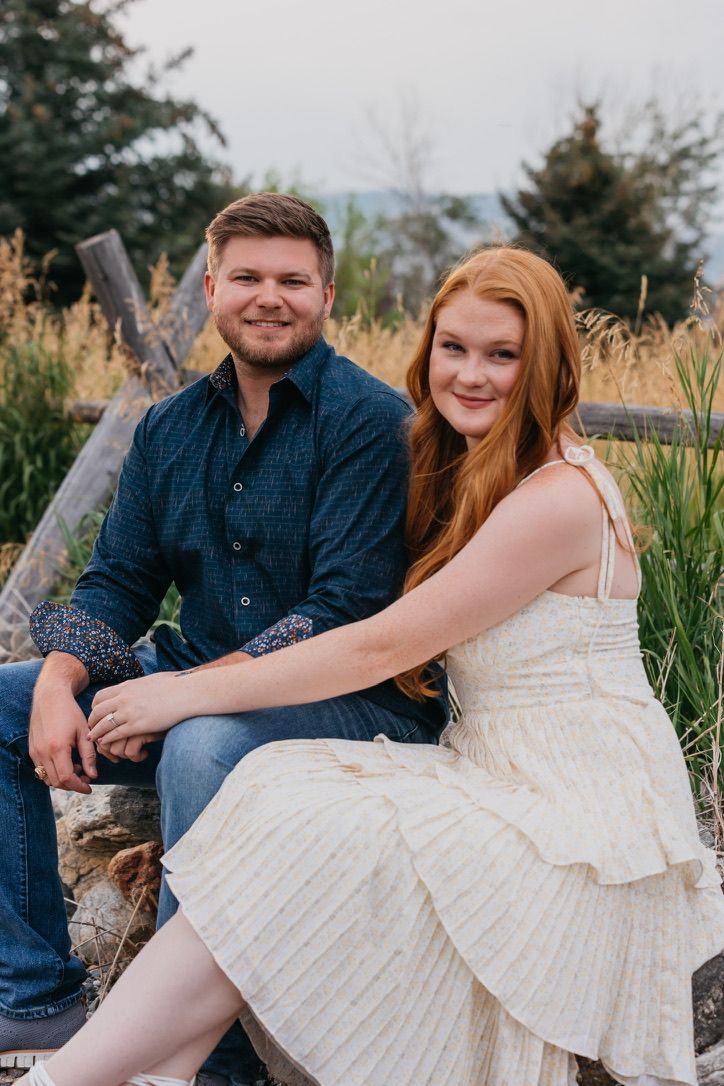 Couple sitting on rustic log bench in garden setting.