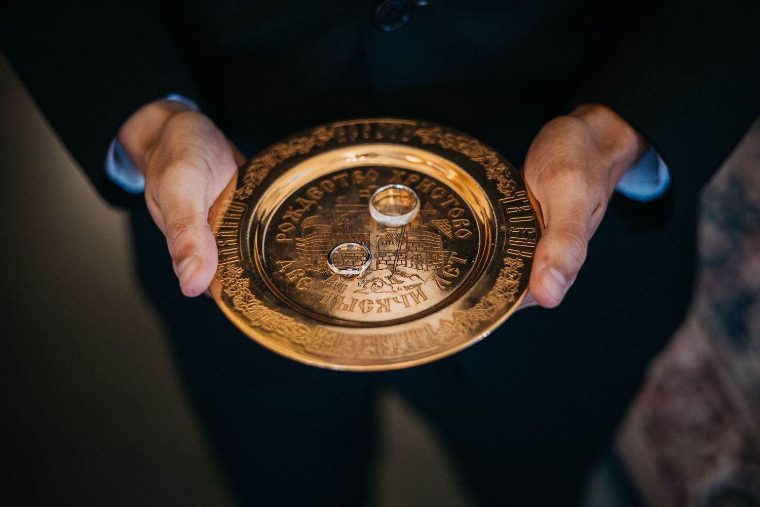 Antique gold decorative plates being held up to display intricate designs and patterns.
